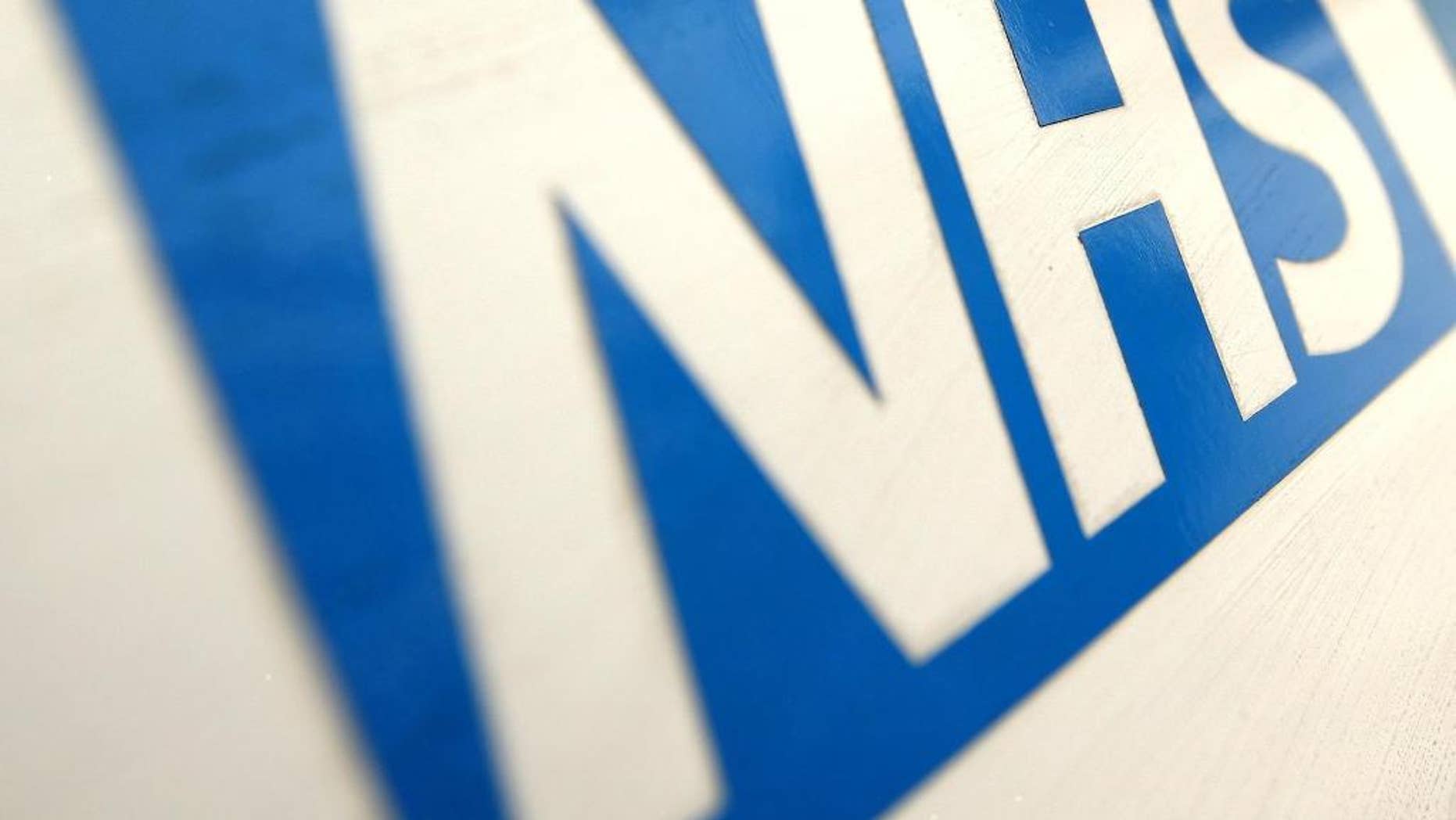 FILE In this Dec. 12, 2010 file photo of the NHS Logo. The British Red Cross says overcrowding in hospital emergency rooms has become a "humanitarian crisis." The charity says it has dispatched volunteers to help patients go home and free up hospital beds. It claims cuts to social-care funding by the Conservative government mean some patients can't be discharged because there is no support available, putting pressure on hospitals. Government supporters say the Red Cross is exaggerating the scale of the problem. (Dominic Lipinski/PA via AP, File)