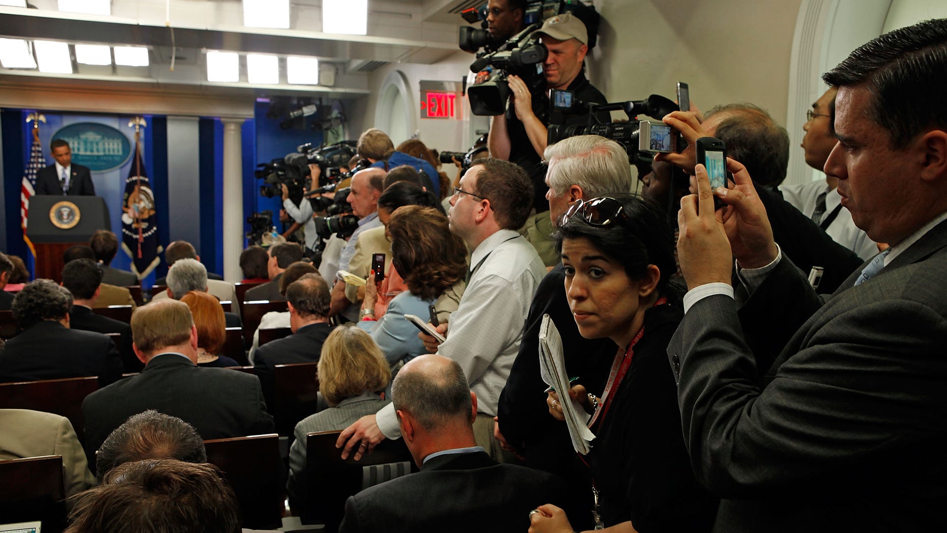 WASHINGTON - JUNE 23: Reporters squeeze in the aisle while using hand-held digital devices to make images of U.S. President Barack Obama during a news conference in the James S. Brady Briefing Room at the White House June 23, 2009 in Washington, DC. Obama was expected to discuss the high cost of health care, energy independence and the post-election disputes in Iran. (Photo by Chip Somodevilla/Getty Images)