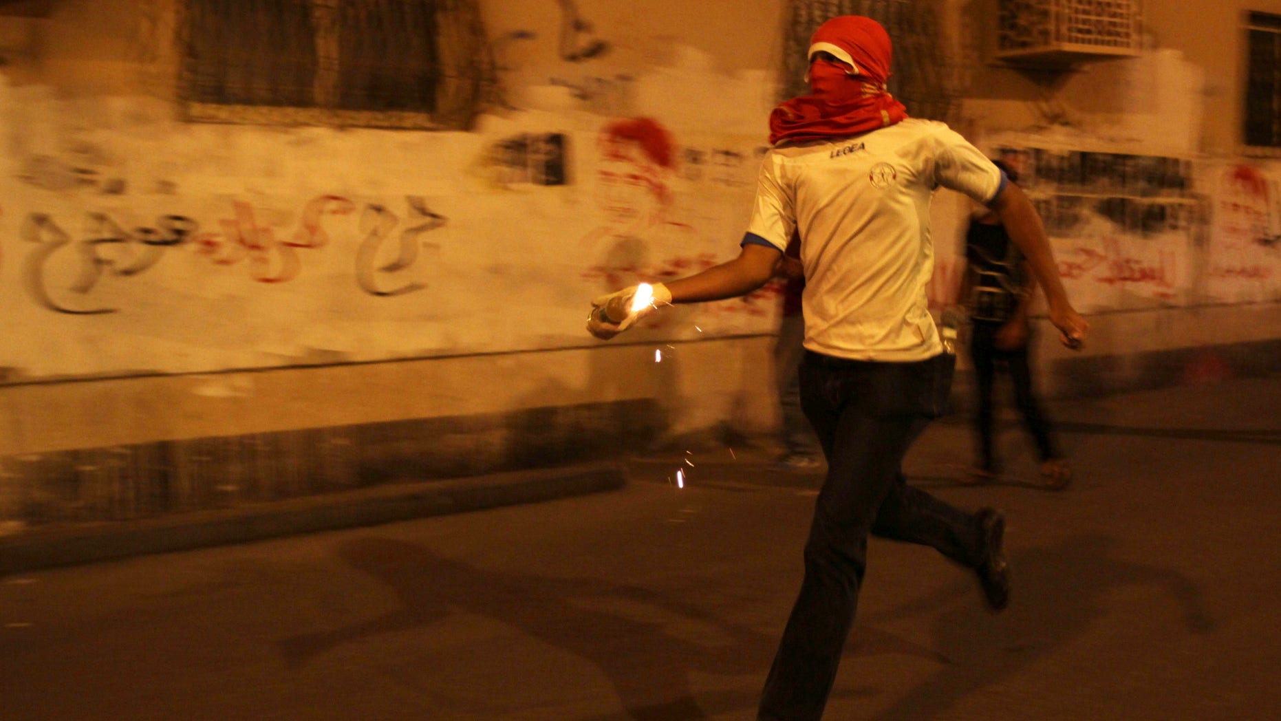 A Bahraini anti-government protester prepares to throw a petrol bomb at riot police during clashes following a rally protesting against the upcoming Formula One race in Sanabis, Bahrain, Tuesday, April 9, 2013. The Bahrain Grand Prix is to be held April 21. Bahrain says four suspects have been arrested after homemade firebombs were hurled at the foreign ministry in a possible escalation of anti-government protests. (AP Photo/Hasan Jamali)