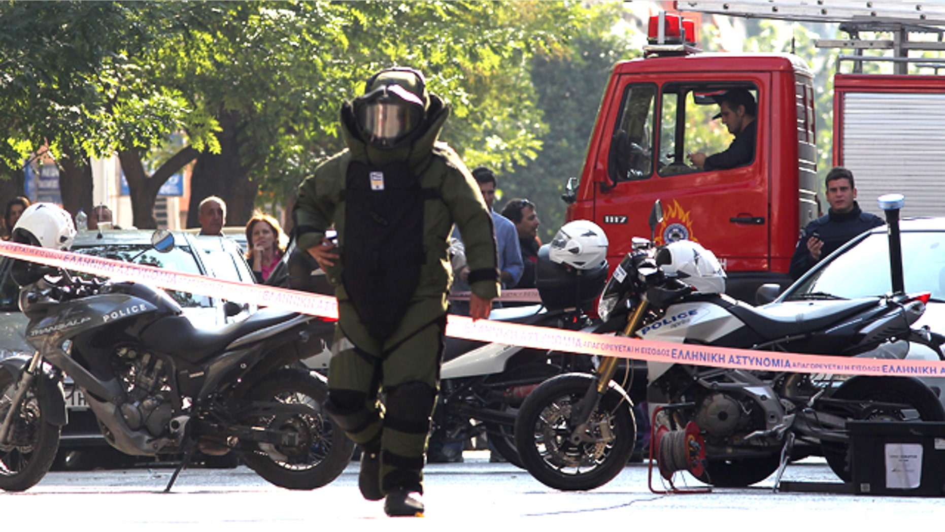 Nov. 1: A police officer prepares for a controlled explosion of a suspect package in Athens, Greece.