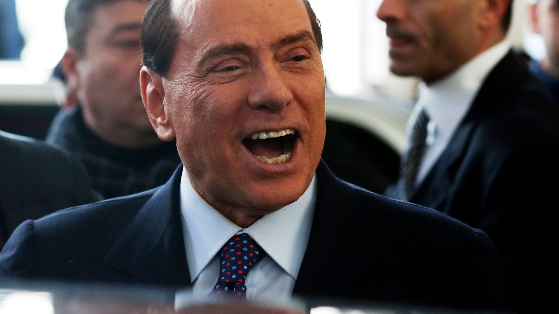 Former Italian premier Silvio Berlusconi smiles as he arrives at Milan's central train station, Italy, Saturday, Dec. 29, 2012. Italian Premier Mario Monti announced Friday he is heading a new campaign coalition made of up centrists, business leaders and pro-Vatican forces who back his "ethical" vision of politics, aiming for a second mandate in office if his fledging reform movement wins big in parliamentary elections. Monti was appointed premier 13 months ago after his scandal-plagued predecessor Silvio Berlusconi failed to stop Italy from sliding deeper into the eurozone debt crisis. He quit earlier this month after Berlusconi pulled his party's support from Monti's government, but is now continuing in a caretaker role until the next elections. (AP Photo/Luca Bruno)