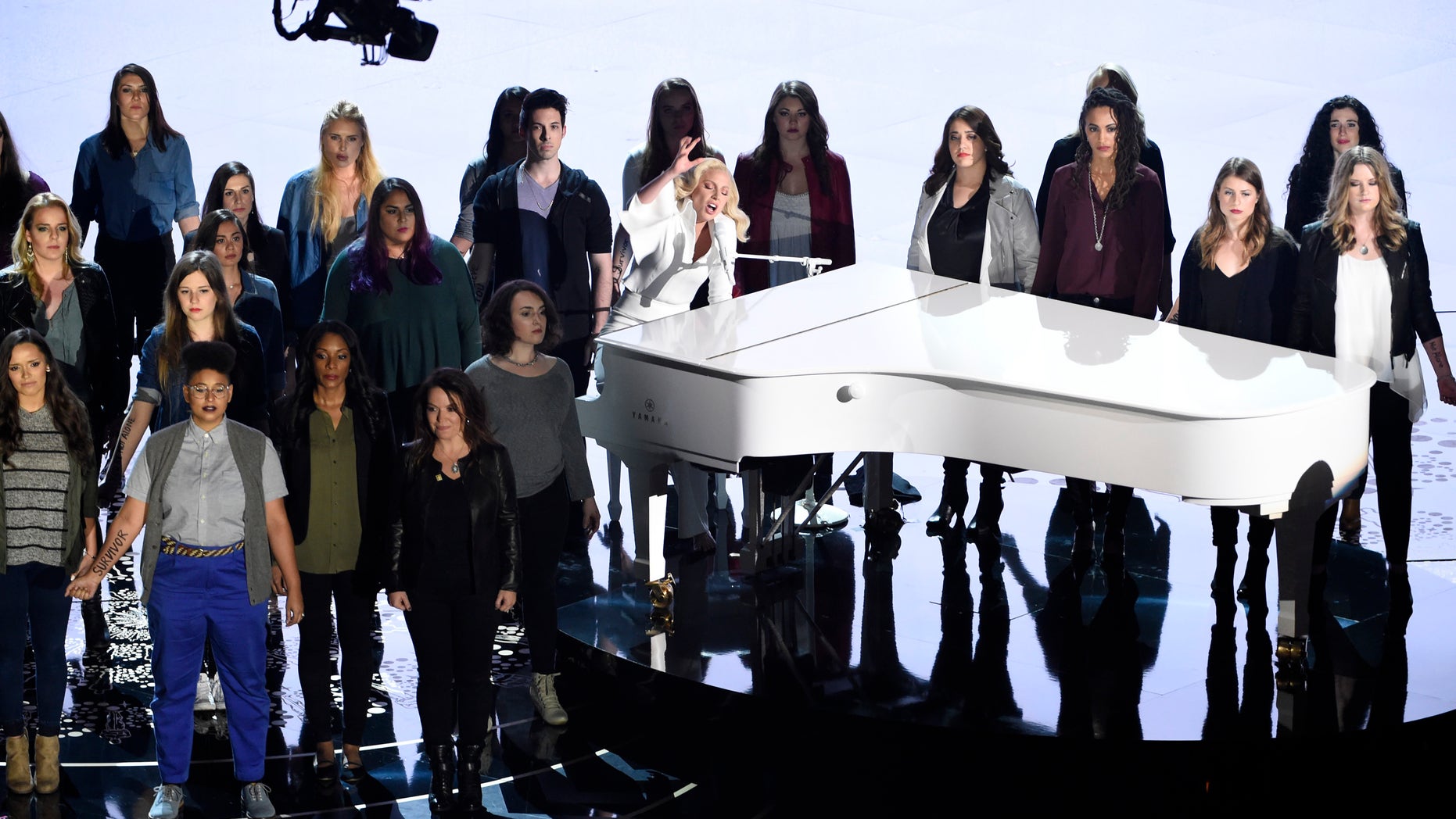 Lady Gaga, center, performs "Til It Happens To You" that is nominated for best original song from "The Hunting Ground" on stage with survivors of abuse at the Oscars on Sunday, Feb. 28, 2016, at the Dolby Theatre in Los Angeles. (Photo by Chris Pizzello/Invision/AP)