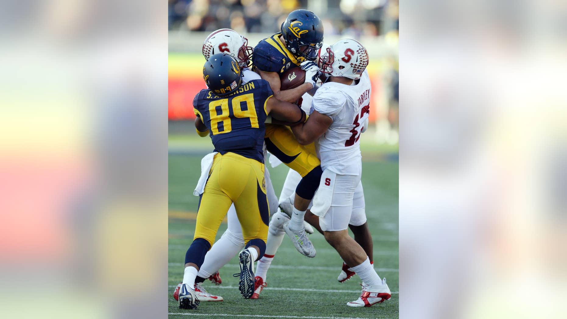 California's Daniel Lasco, second from right, is picked up by Stanford's A.J. Tarpley, right, during the second half of an NCAA college football game Saturday, Nov. 22, 2014, in Berkeley, Calif. At left is California's Stephen Anderson (89). (AP Photo/Ben Margot)