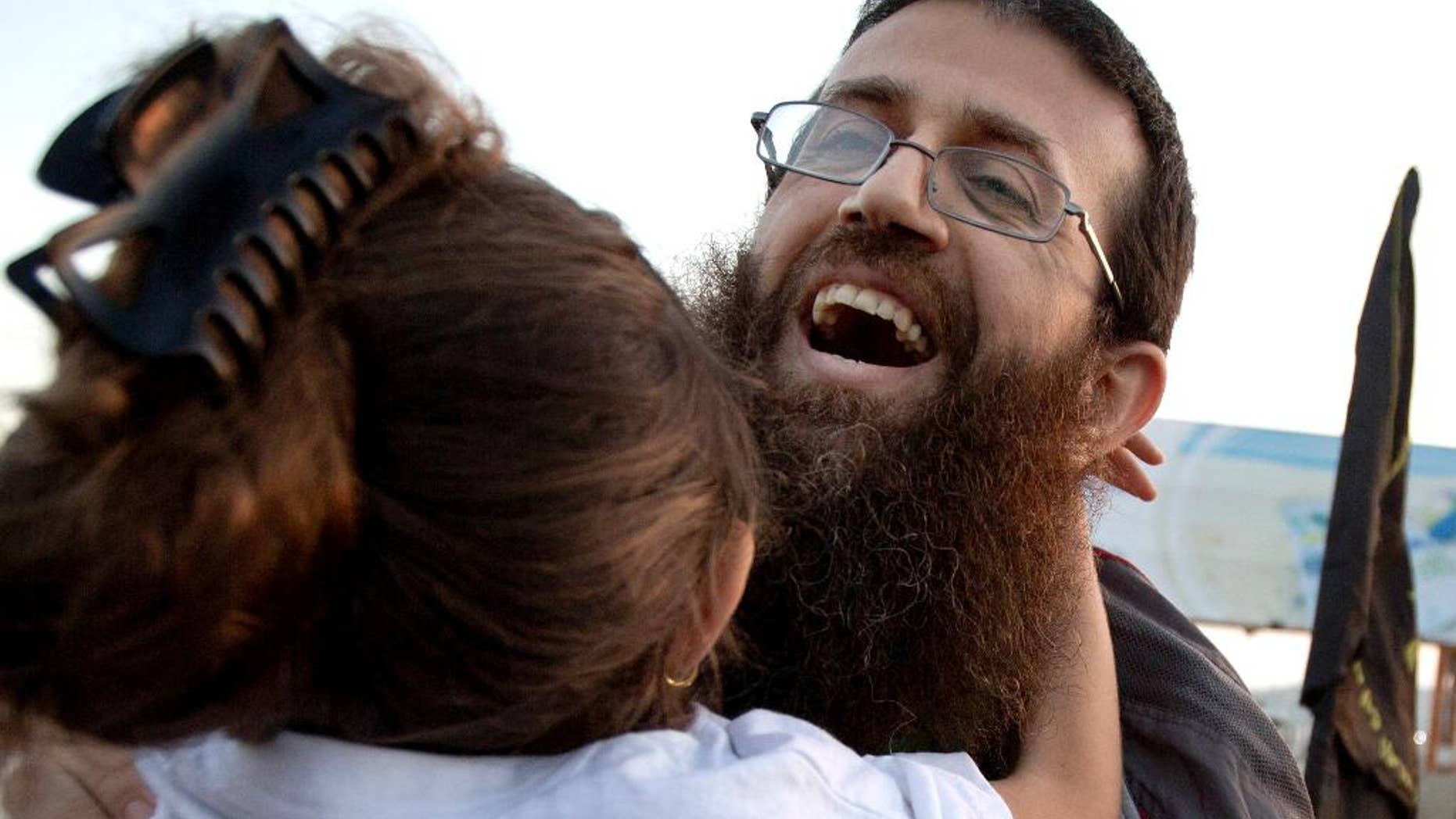 FILE - In this Sunday, July 12, 2015 file photo, Palestinian Khader Adnan hugs his daughter after his release from an Israeli prison in the West Bank village of Arrabeh near Jenin. Israeli police said they have detained Adnan again, just a day after he was released from Israeli custody. Police said Adnan was detained Monday in Jerusalem's Old City because he didn't have an Israeli permit to be in the area. He was detained as throngs of Muslim worshippers were visiting Jerusalem for a Muslim holy night. (AP Photo/Majdi Mohammed, File)