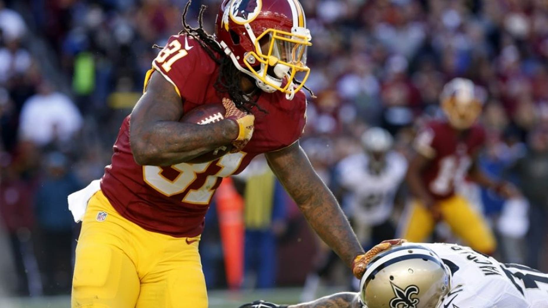 Nov 15, 2015; Landover, MD, USA; Washington Redskins running back Matt Jones (31) carries the ball as New Orleans Saints strong safety Kenny Vaccaro (32) attempts the tackle in the second quarter at FedEx Field. Mandatory Credit: Geoff Burke-USA TODAY Sports