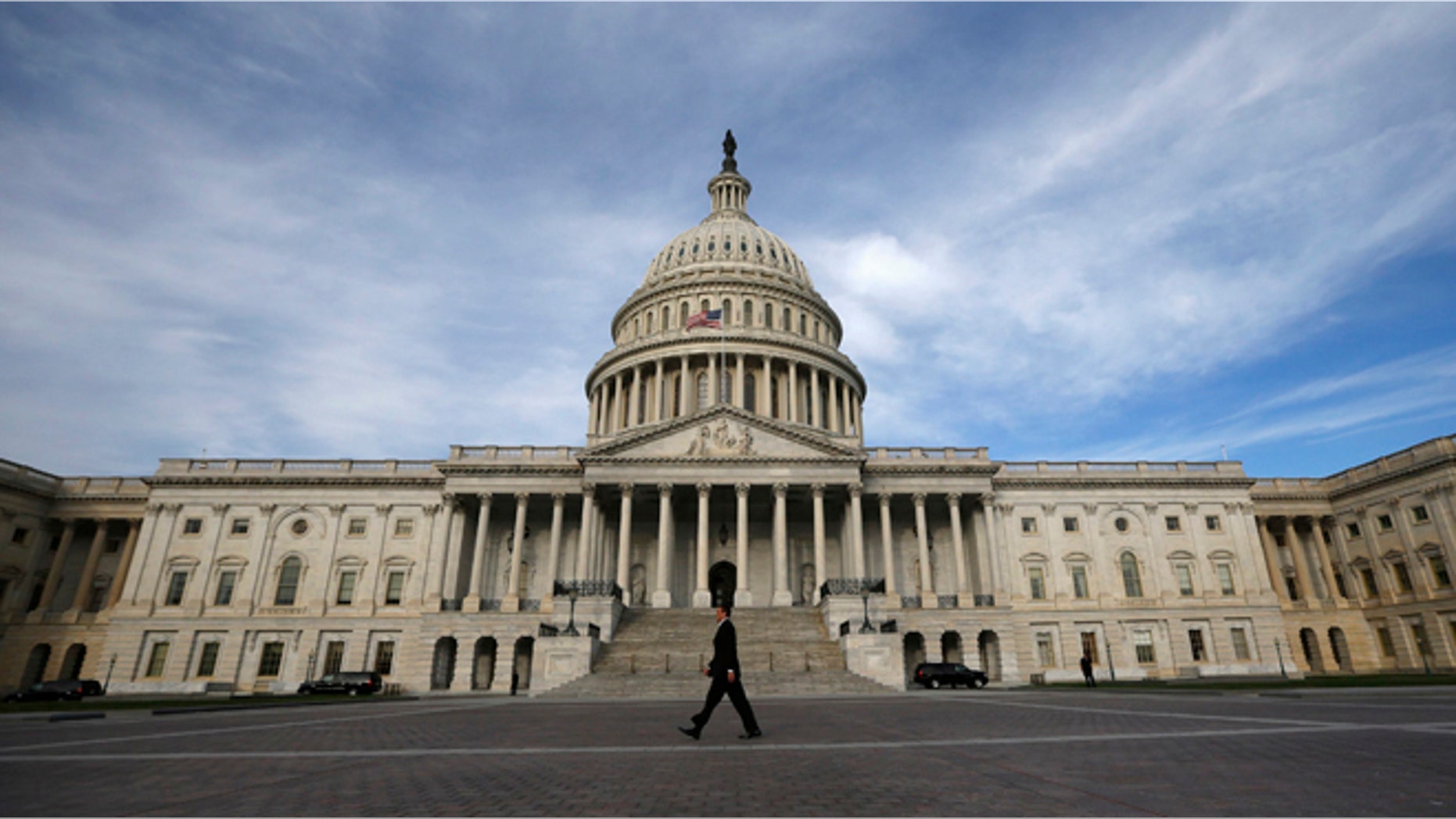 A lone worker passes by the U.S. Capitol building in Washington, October 8, 2013.