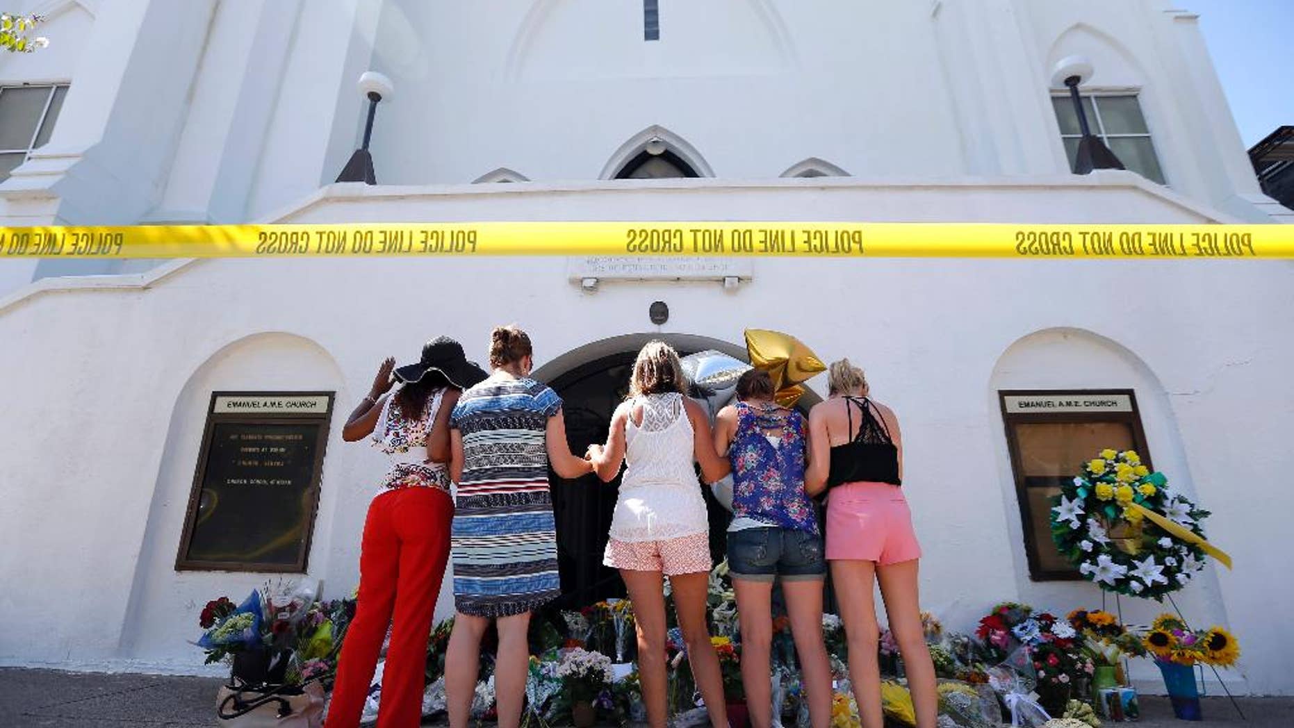 June 18, 2015: A group of women pray together at a makeshift memorial on the sidewalk in front of the Emanuel AME Church in Charleston, S.C.