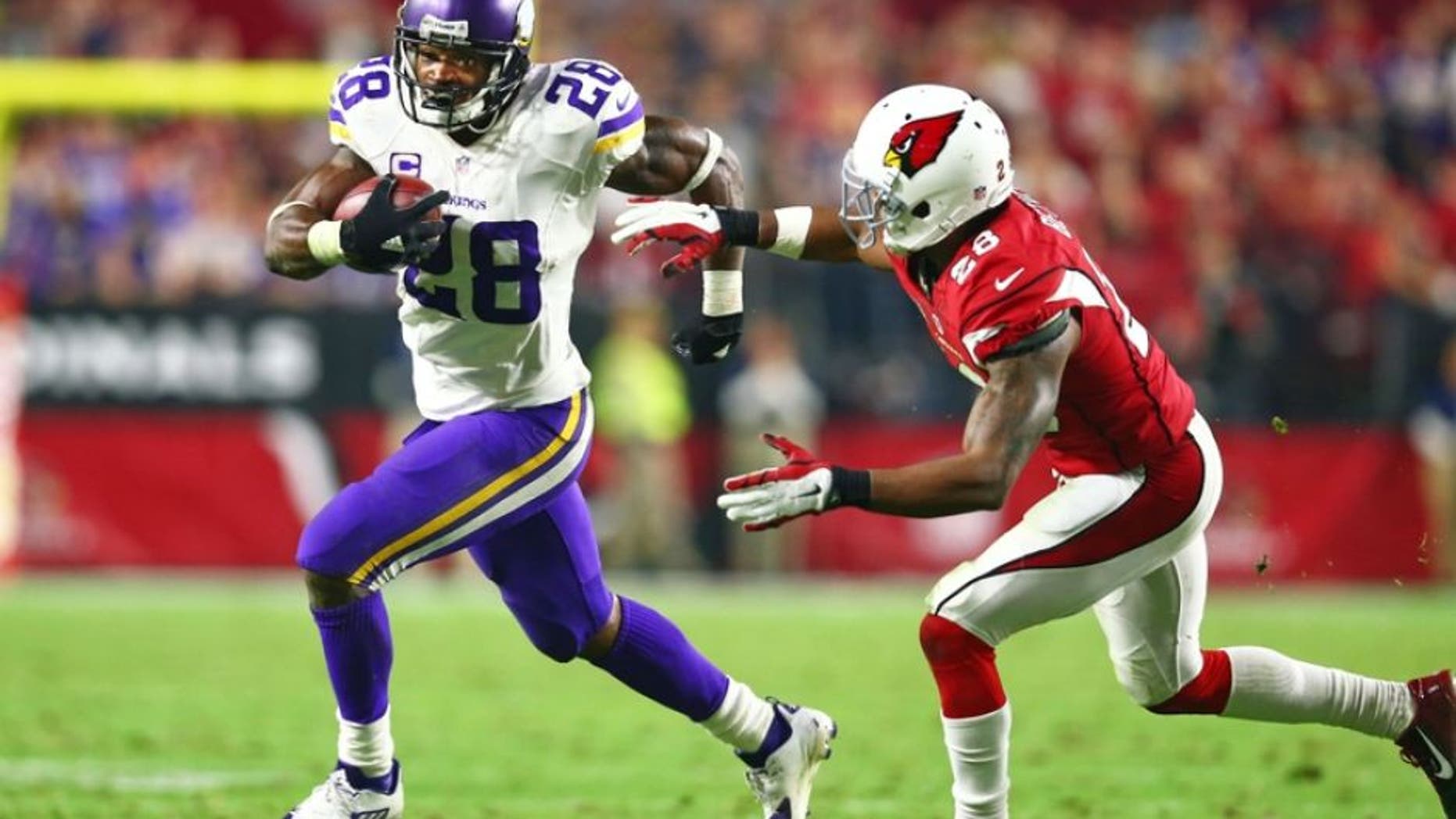 Dec 10, 2015; Glendale, AZ, USA; Minnesota Vikings running back Adrian Peterson (left) runs the ball against Arizona Cardinals cornerback Justin Bethel in the fourth quarter at University of Phoenix Stadium. The Cardinals defeated the Vikings 23-20. Mandatory Credit: Mark J. Rebilas-USA TODAY Sports