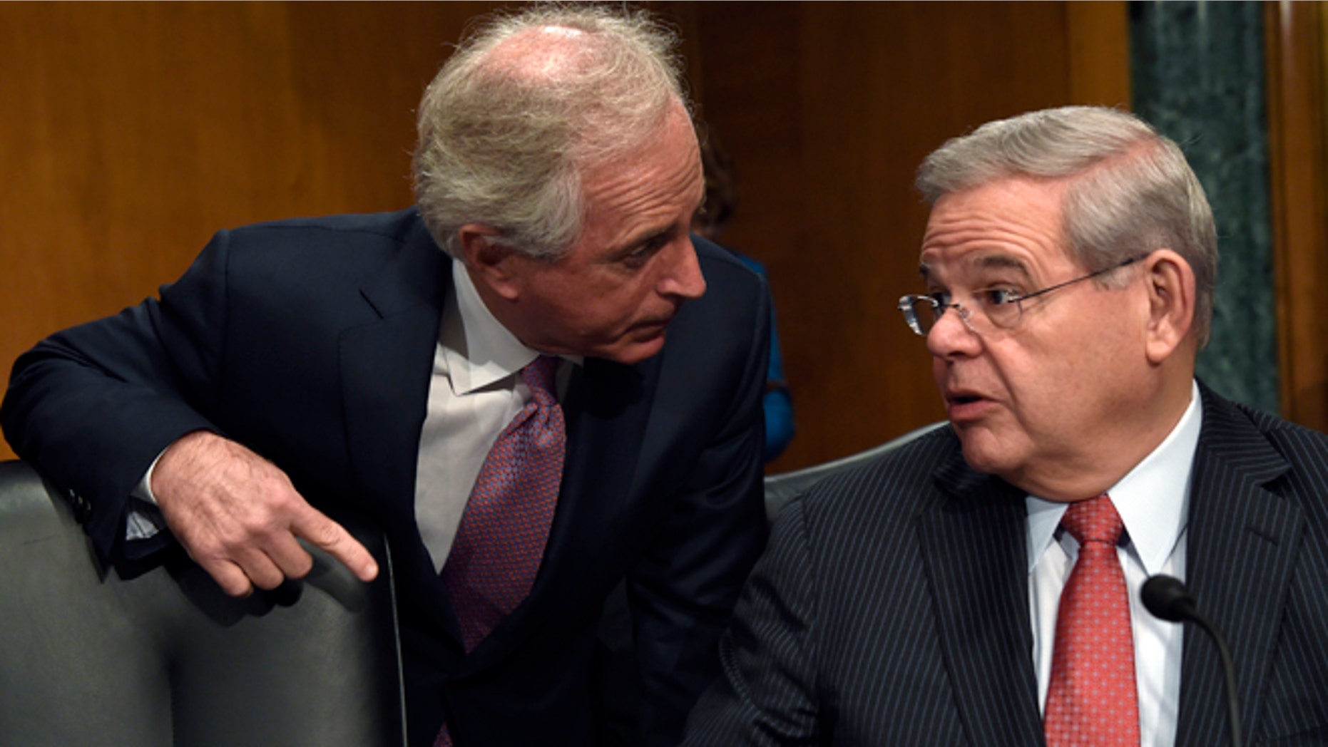 FILE - In this Jan. 27, 2015 file photo, Sen. Robert Menendez, D-N.J., right, and Sen. Bob Corker, R-Tenn. talk on Capitol Hill in Washington. A bipartisan bill in the Senate would set up a nonprofit foundation to help eliminate forced labor and sexual servitude around the world. The Senate Foreign Relations Committee is to vote Thursday on the bill introduced by chairman Sen. Bob Corker, R-Tenn., and Robert Menendez, D-N.J., the ranking Democrat on the committee. (AP Photo/Susan Walsh, File)