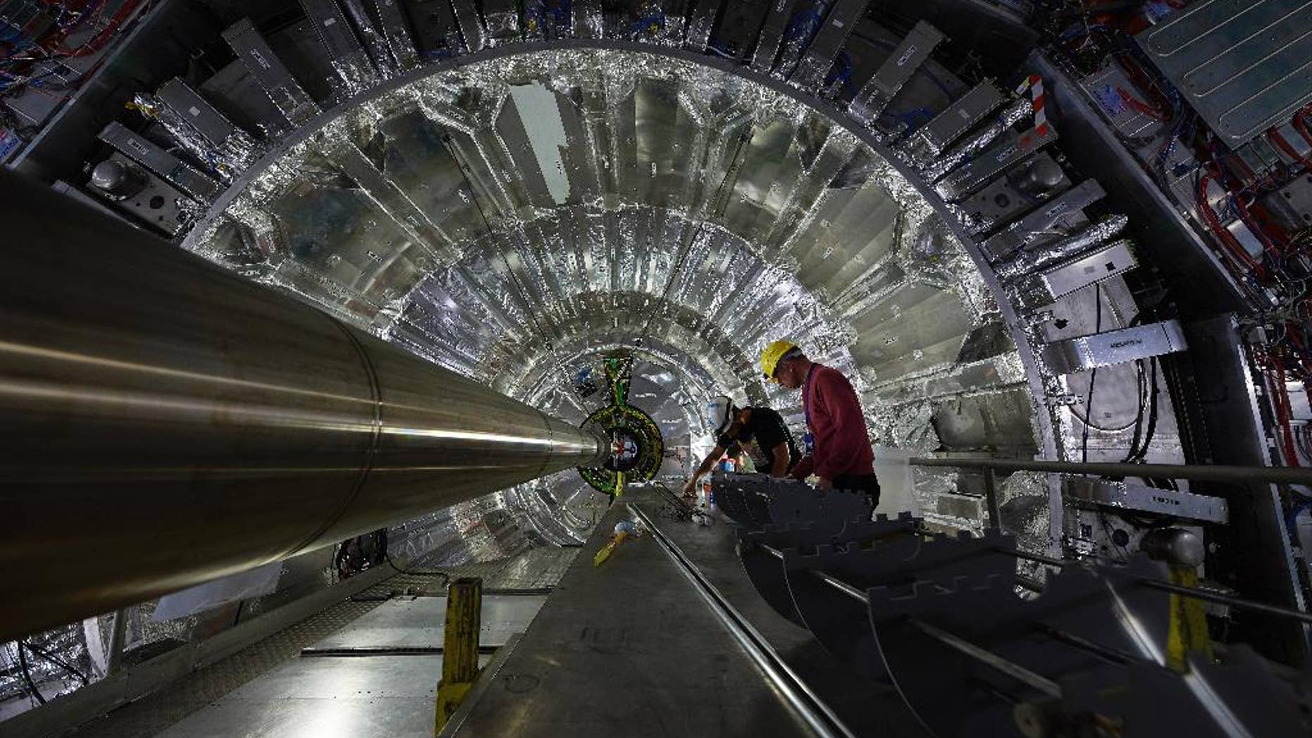 In this undated picture publicly provided by the European Organization for Nuclear Research, CERN, employees and scientists prepare the upgrading of one of the four main experiments on the world’s biggest atom smasher in the hope it will help them discover previously unknown particles or physical properties at CERN near Geneva. Officials at CERN, said the operations the equivalent of a “heart transplant” for the CMS experiment. CMS was key to confirming the existence of the Higgs boson particle in 2012. (CERN via AP)