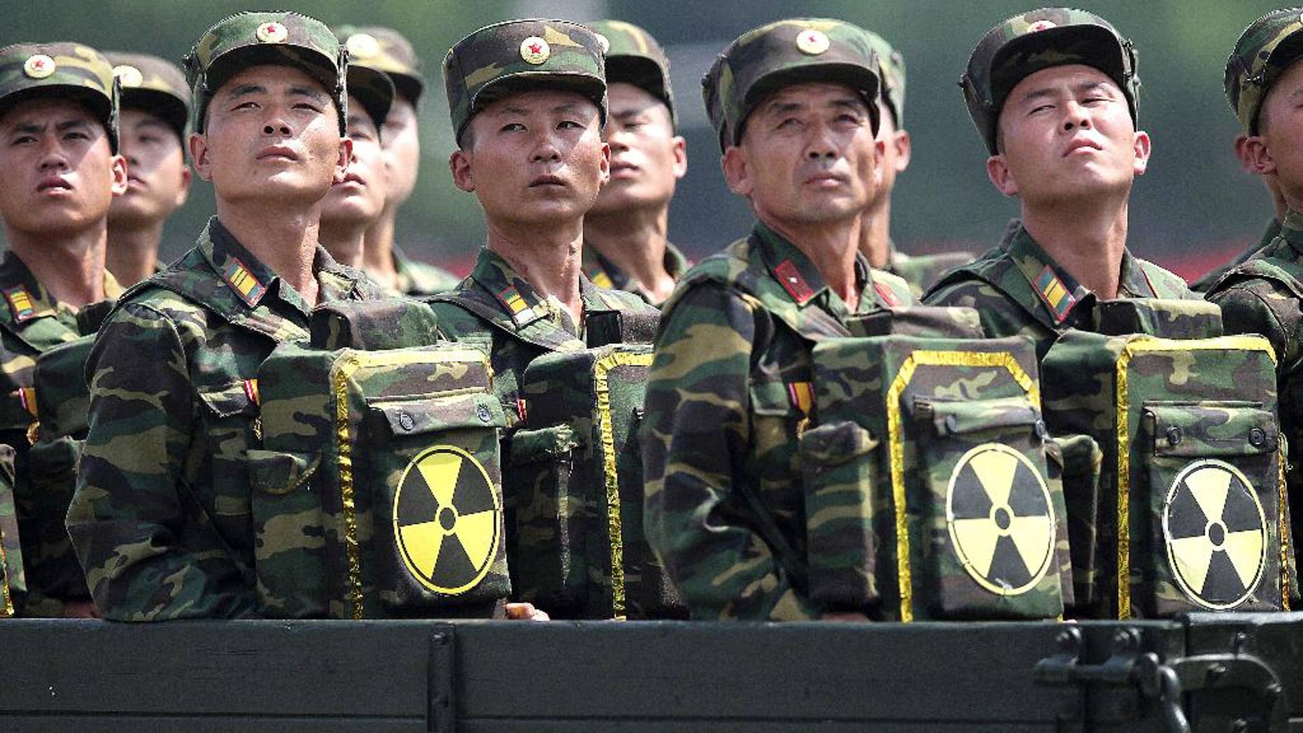 FILE - In this July 27, 2013, file photo, North Korean soldiers turn and look towards their leader Kim Jong Un from a military parade vehicle as they carry packs marked with the nuclear symbol during a ceremony marking the 60th anniversary of the Korean War armistice in Pyongyang, North Korea. Mark up another first for North Korea - two nuclear tests in one year. With few other options, or allies to rally behind it, this is how Pyongyang likes to play its cards in the power game that is northeast Asian politics. The question is whether it can play them well enough to get what it really wants: international recognition, security guarantees and, at the most fundamental level, its own continued survival. (AP Photo/Wong Maye-E, File)