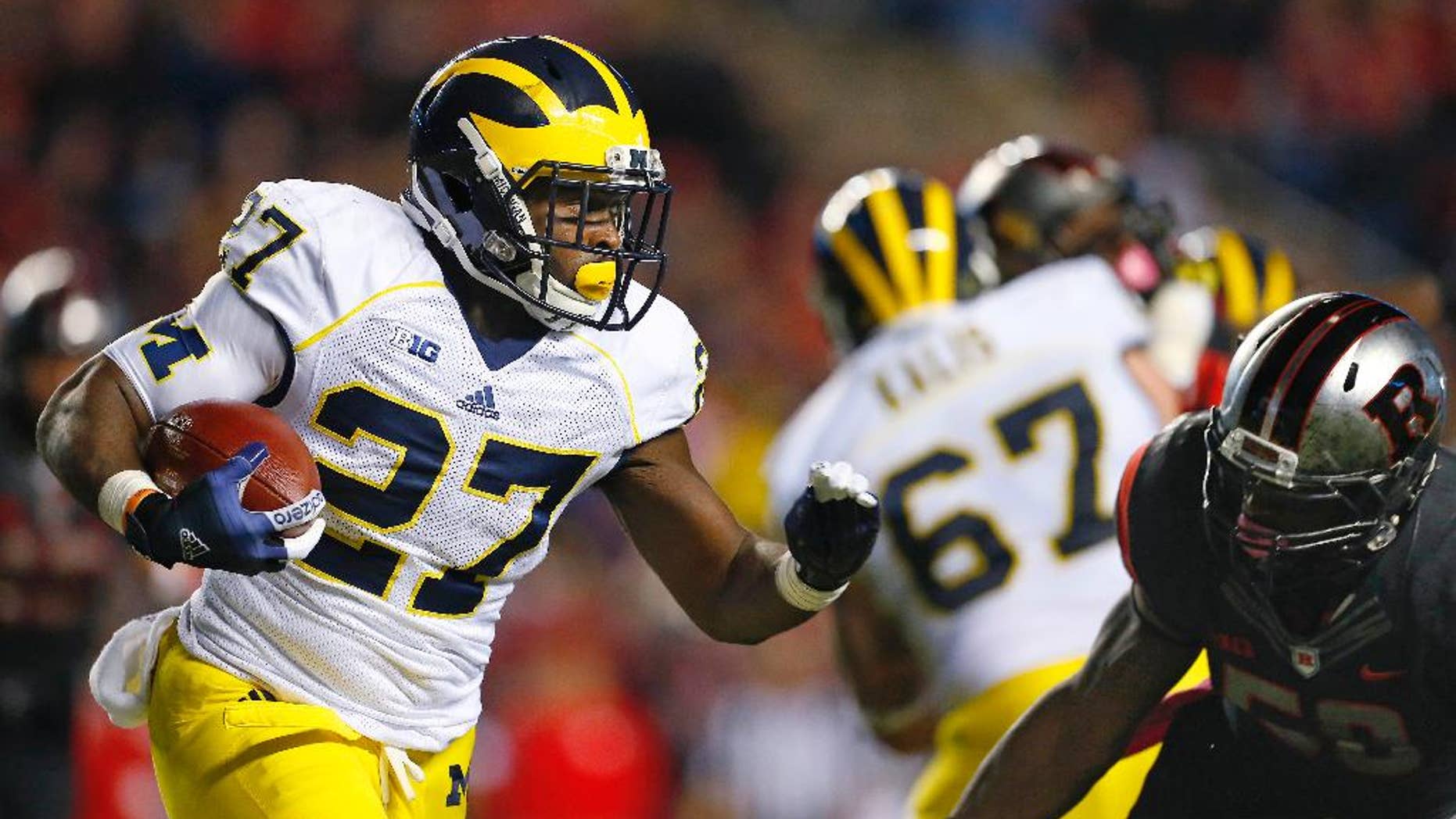 Michigan running back Derrick Green (27) is pursued by Rutgers' Quentin Gause during the second half of an NCAA college football game Saturday, Oct. 4, 2014, in Piscataway, N.J. Rutgers defeated Michigan 26-24. (AP Photo/Rich Schultz)