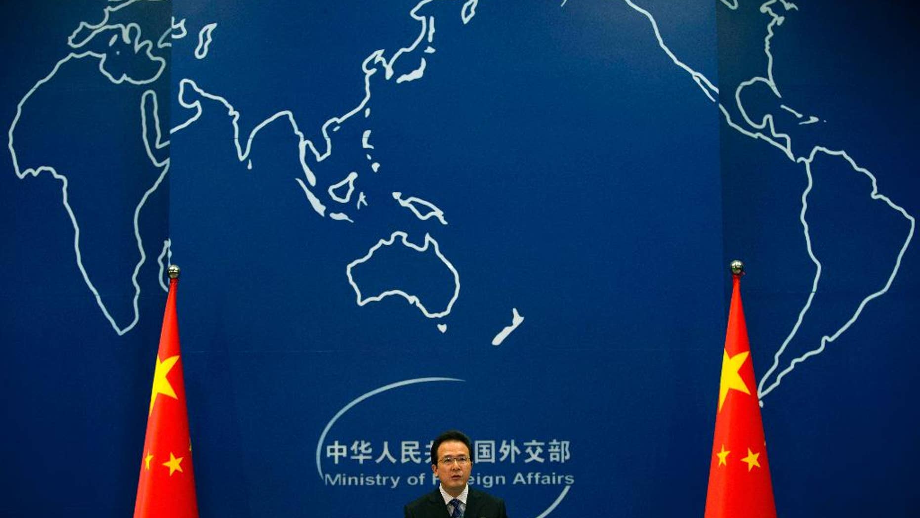 FILE - In this May 20, 2014 file photo, Foreign Ministry spokesman Hong Lei speaks during a daily briefing at the Ministry of Foreign Affairs office in Beijing, China. China said Thursday, May 21, 2015 it is entitled to keep watch over airspace and seas surrounding artificial islands it created in the disputed waters of the South China Sea, following a reported exchange in which its navy warned off a U.S. surveillance plane. Speaking at a regular daily briefing, Hong reiterated Beijing's insistence on its indisputable sovereignty over the islands it has created by piling sand on top of atolls and reefs. (AP Photo/Andy Wong, File)