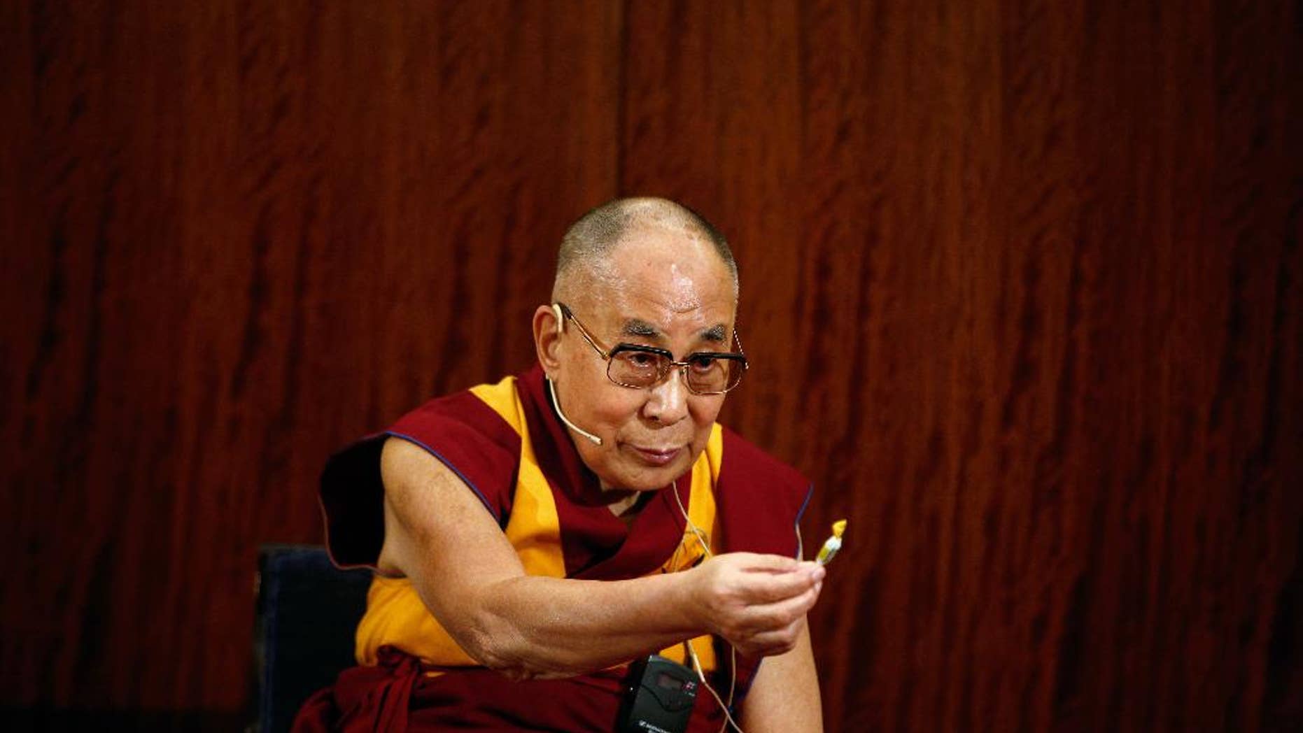 Tibetan spiritual leader, the Dalai Lama offers a sweet to a person, during a press conference , in Paris, Tuesday, Sept. 13, 2016. The Dalai Lama says there should be dialogue with Islamic State extremists to end bloodshed in Syria and Iraq, and argues that religion is never a justification for bloodshed. The spiritual leader is on a six day visit to France. (AP Photo/Thibault Camus)