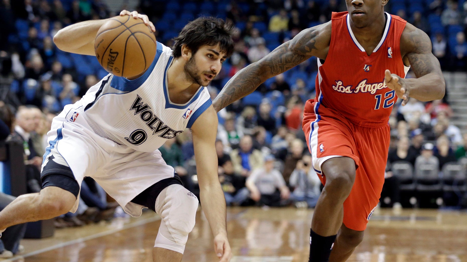 Minnesota Timberwolves' Ricky Rubio of Spain, left, maintains his balance as he drives past Los Angeles Clippers' Eric Bledsoe in the first half of an NBA basketball game Wednesday, Jan. 30, 2013 in Minneapolis. (AP Photo/Jim Mone)