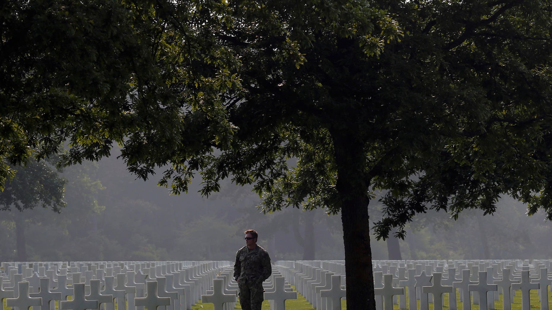 CORRECTS YEAR TO 2016- An American soldier, no name given, walks in the Colleville American military cemetery, in Colleville sur Mer, western France, Sunday June 5, 2016, on the eve of the 72nd anniversary of the D-Day landing. D-Day marked the start of a Europe invasion, as many thousands of Allied troops began landing on the beaches of Normandy in northern France in 1944 at the start of a major offensive against the Nazi German forces, an offensive which cost the lives of many thousands. (AP Photo/Francois Mori)