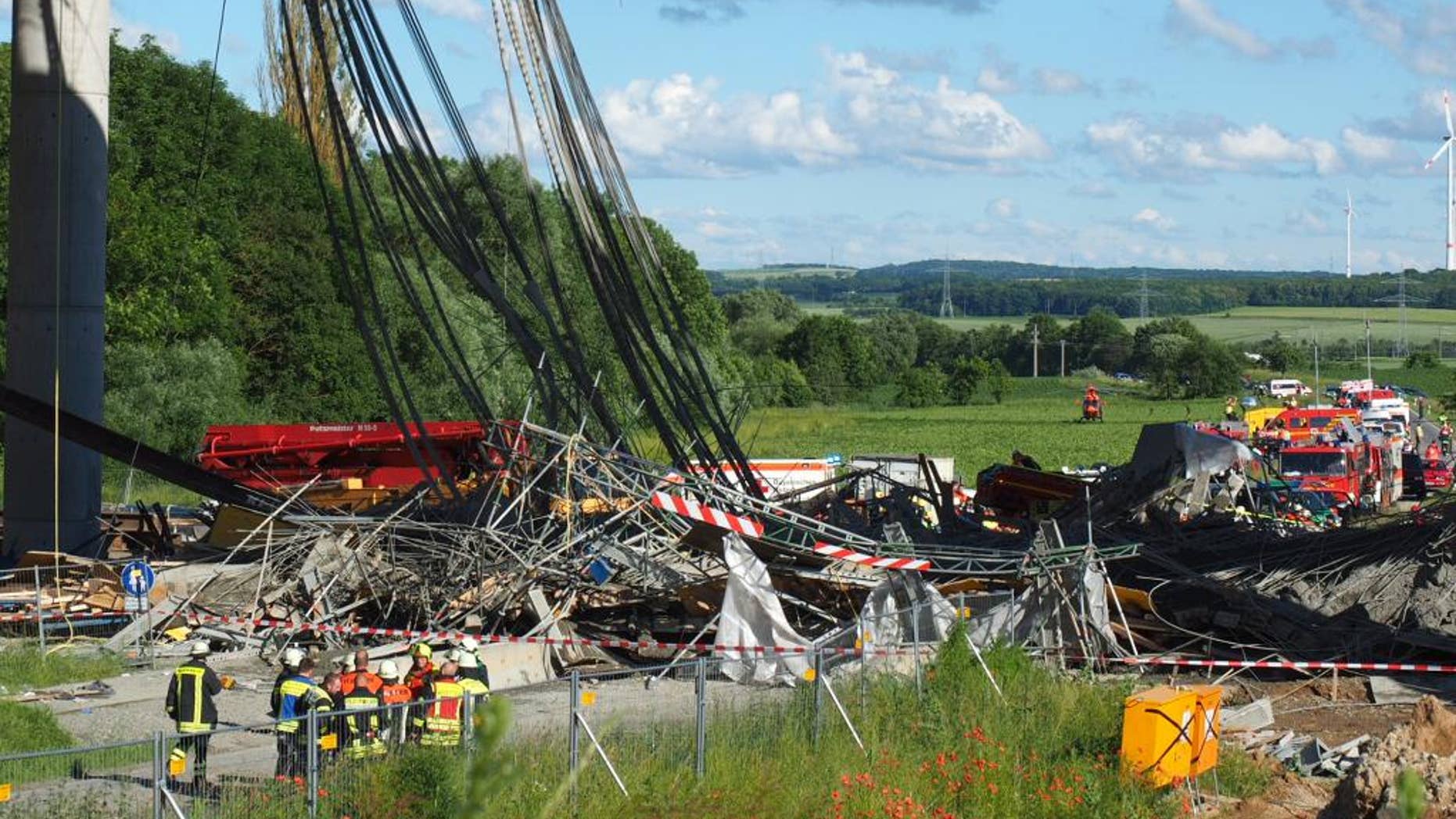 Firefighters stand near a collapsed scaffolding at a highway bridge near Werneck northern Bavaria, Germany Wednesday June 15, 2016. German news agency dpa is reporting that the scaffolding has collapsed on a highway bridge that was under construction in southern Germany. ( Nicolas Armer/dpa via AP)