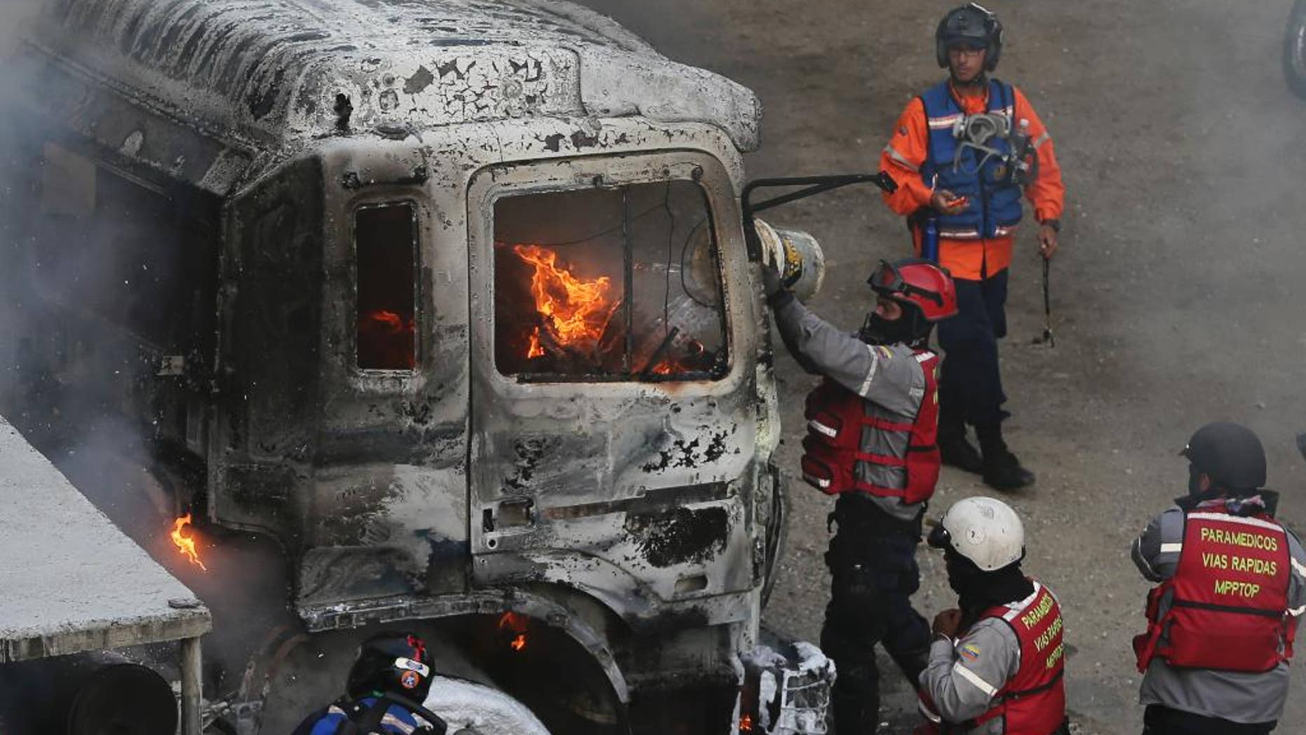 Fire-fighters put out a truck set on fire during anti-government protests in Caracas, Venezuela, Monday, April 24, 2017. Thousands of protesters shut down the capital city's main highway to express their disgust with the socialist administration of President Nicolas Maduro. Protesters in least a dozen other cities also staged sit-ins as the protest movement is entering its fourth week. (AP Photo/Fernando Llano)