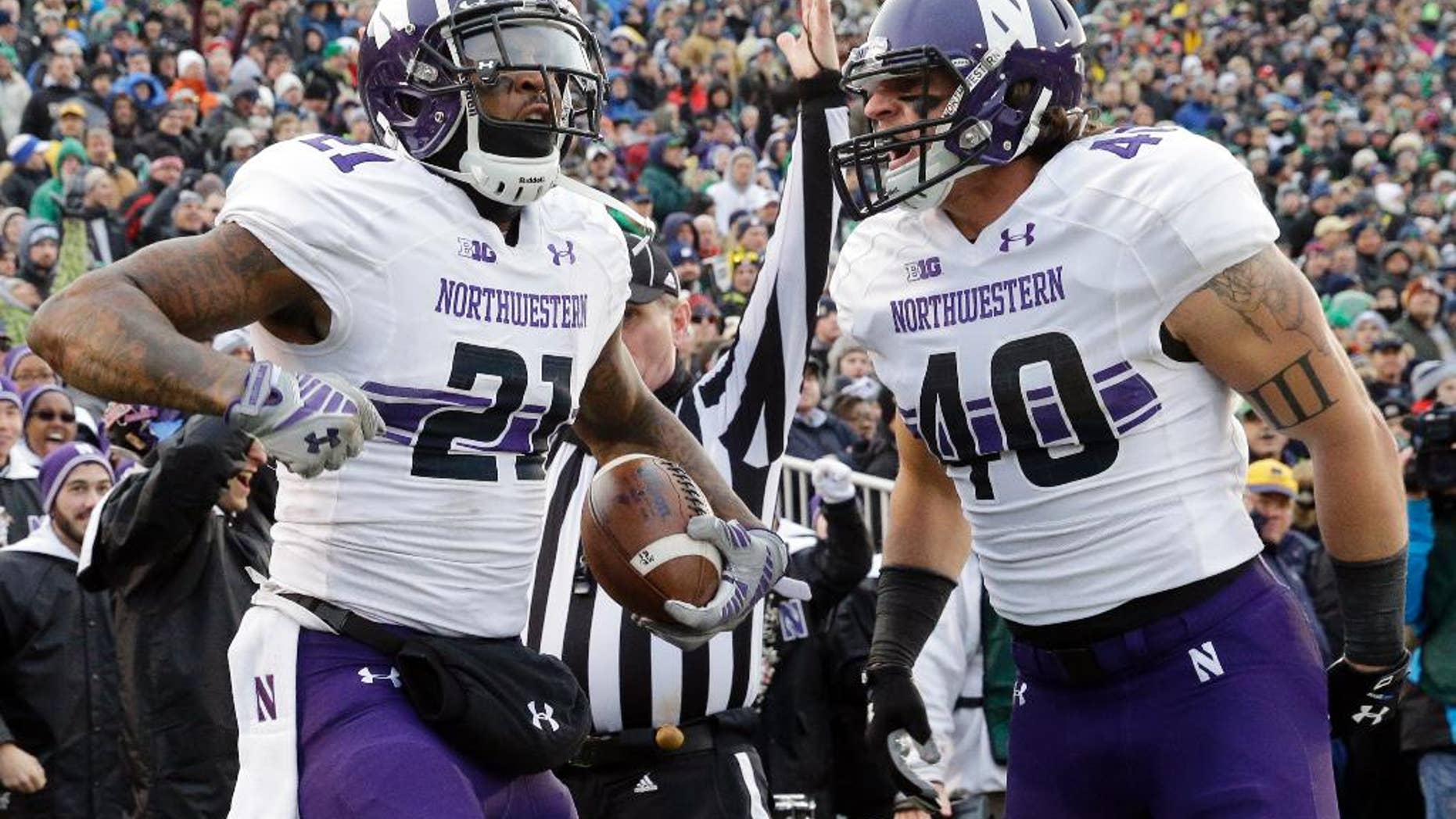 Northwestern wide receiver Kyle Prater (21) celebrates with super back Dan Vitale (40) after catching a touchdown pass during the first half of an NCAA college football game against Notre Dame in South Bend, Ind., Saturday, Nov. 15, 2014. (AP Photo/Nam Y. Huh)