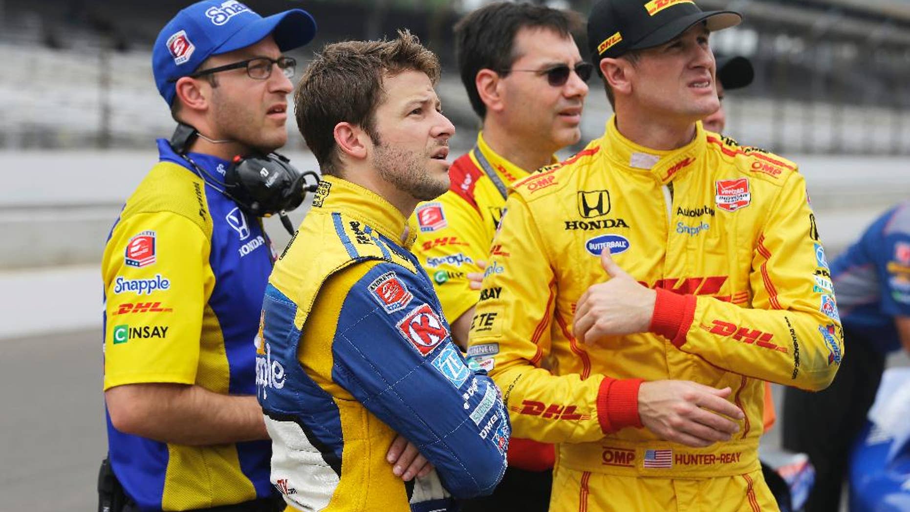 Marco Andretti, front left, and Ryan Hunter-Reay, front right, watch the wreck of James Hinchcliffe, of Canada, on a video screen during practice for the Indianapolis 500 auto race at Indianapolis Motor Speedway in Indianapolis, Monday, May 18, 2015. (AP Photo/Darron Cummings)