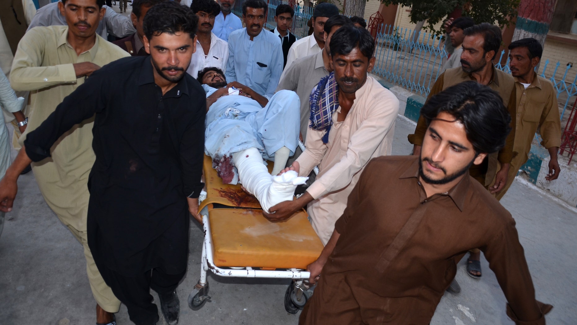People rush an injured person to a hospital after a bomb blast in Pakistan.