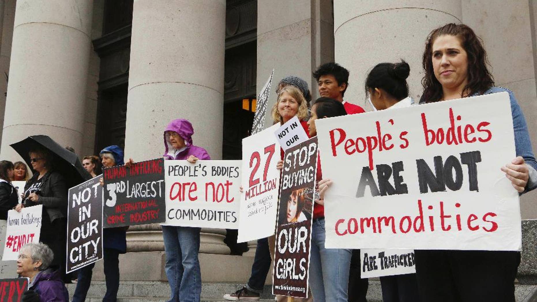 FILE - In this Oct. 21, 2014 file photo, people opposed to child sex trafficking rally outside of the Washington state Supreme Court in Olympia, Wash. The Washington Supreme Court ruled Thursday, Sept. 3, 2015, in favor of three young girls who sued Backpage.com, claiming they were sold as prostitutes on the site. Thursday's ruling says the Communications Decency Act does not protect Backpage from state lawsuits because there's enough evidence to show that it didn't just host the ads, but helped develop the content. (AP Photo/Rachel La Corte, File)