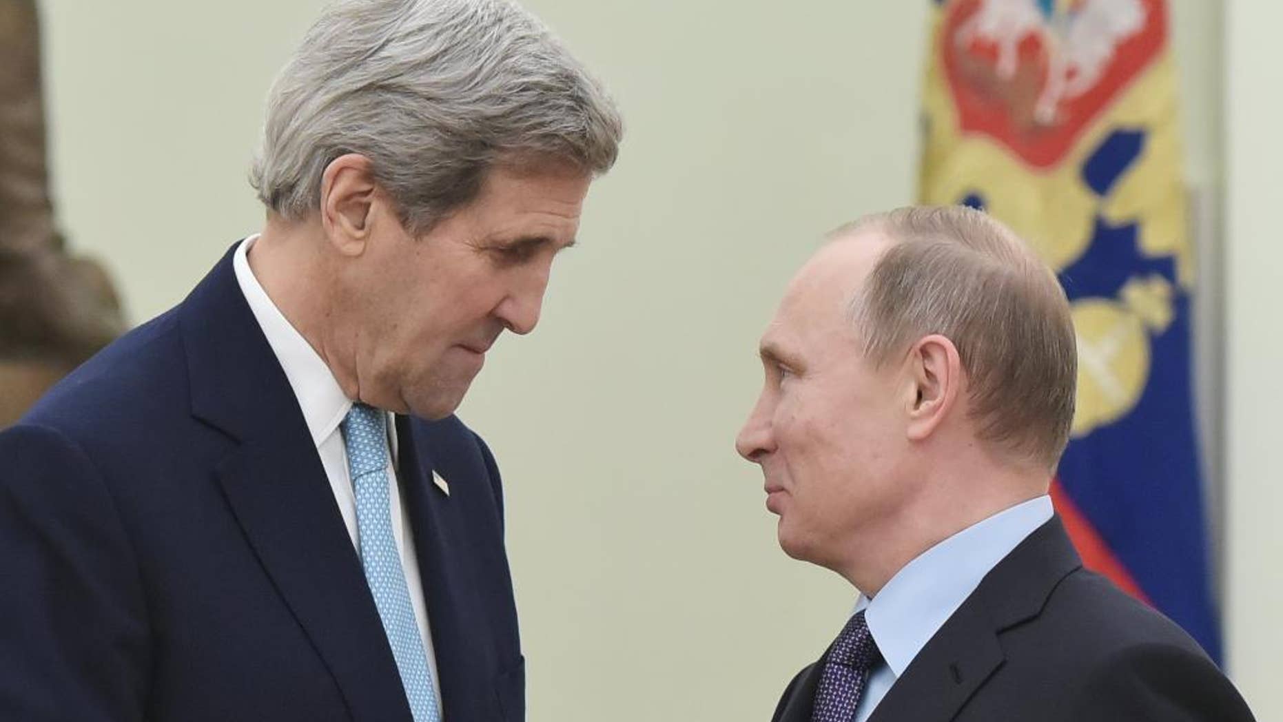 US Secretary of State John Kerry, left, speaks with Russia's President Vladimir Putin during a meeting at the Kremlin in Moscow Tuesday, Dec. 15, 2015. The United States and Russia need to find "common ground" to end Syria's civil war and restore stability in eastern Ukraine, U.S. Secretary of State John Kerry said Tuesday. (Mandel Ngan/Pool Image via AP)