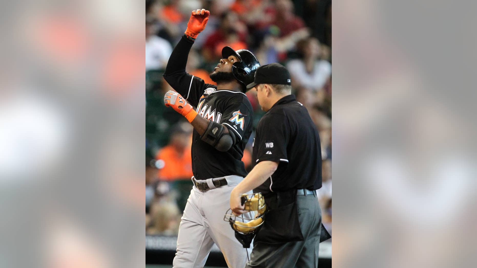 Miami Marlins Marcell Ozuna points to the sky while crossing home plate after hitting a home run during the sixth inning of a baseball game against the Houston Astros, Sunday, July 27, 2014, in Houston. (AP Photo/Patric Schneider)