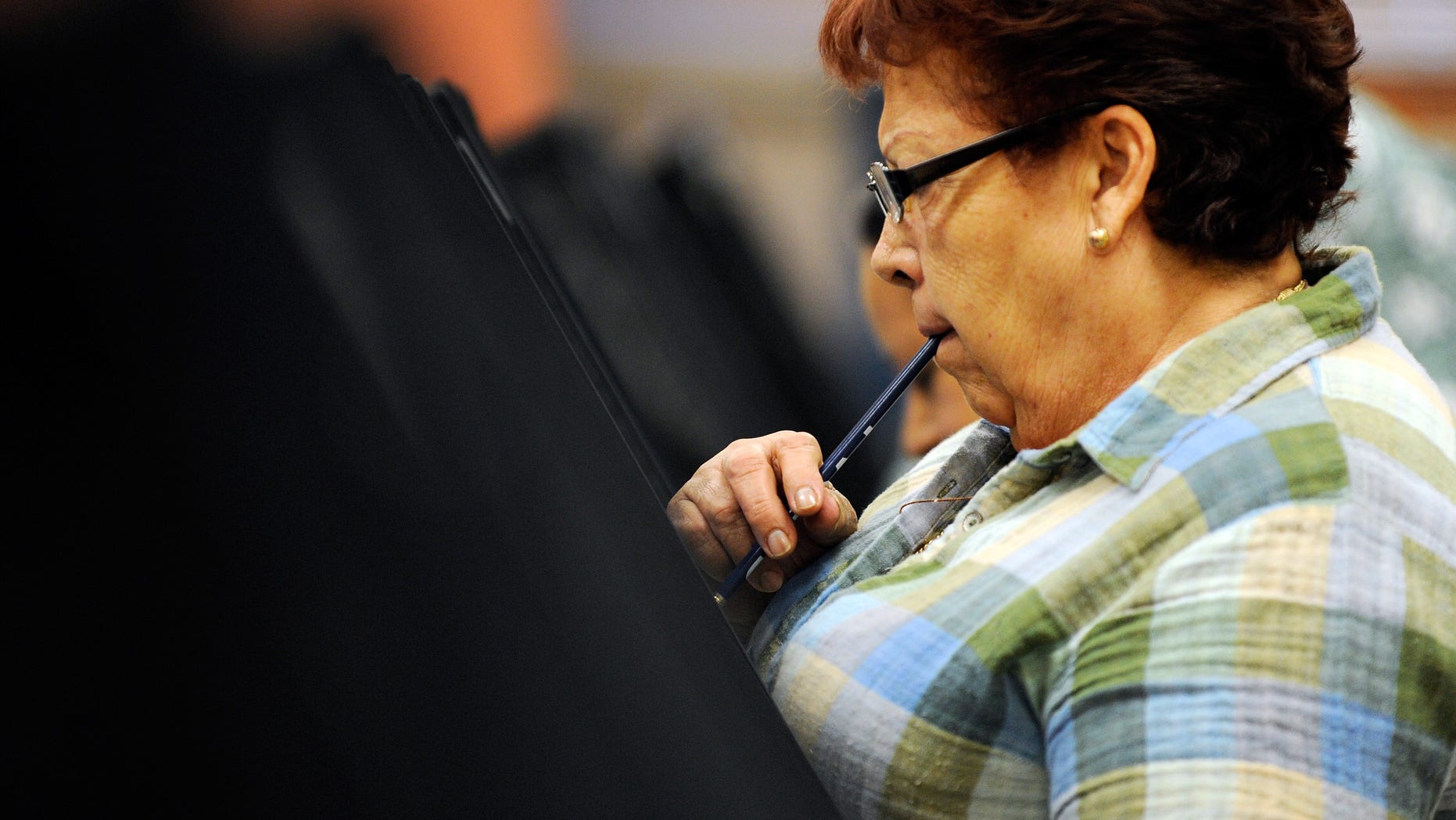 LAS VEGAS, NV - OCTOBER 20: Voting for the first time, Maria Conception ponders her vote as she casts her ballot during the first day of early voting in Nevada at the East Las Vegas Community Center polling station October 20, 2012 in Las Vegas, Nevada. Early voting continues in the battleground state of Nevada until November 2 with election day on November 6. (Photo by David Becker/Getty Images)