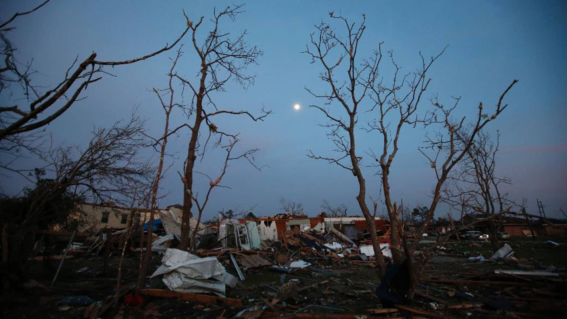 FILE - In this Feb. 8, 2017 file photo, the moon rises over a destroyed neighborhood in the aftermath of a tornado that tore through the New Orleans East section of New Orleans. Forecasters are warning of severe storms as a powerful system moves across the central United States, the start of what could a turbulent stretch of spring weather over the next few days. The bull's-eye for some of the most fearsome weather _ including possible tornadoes, s over parts of Louisiana, Arkansas and east Texas on Friday, March 24 forecasters said. (AP Photo/Gerald Herbert)