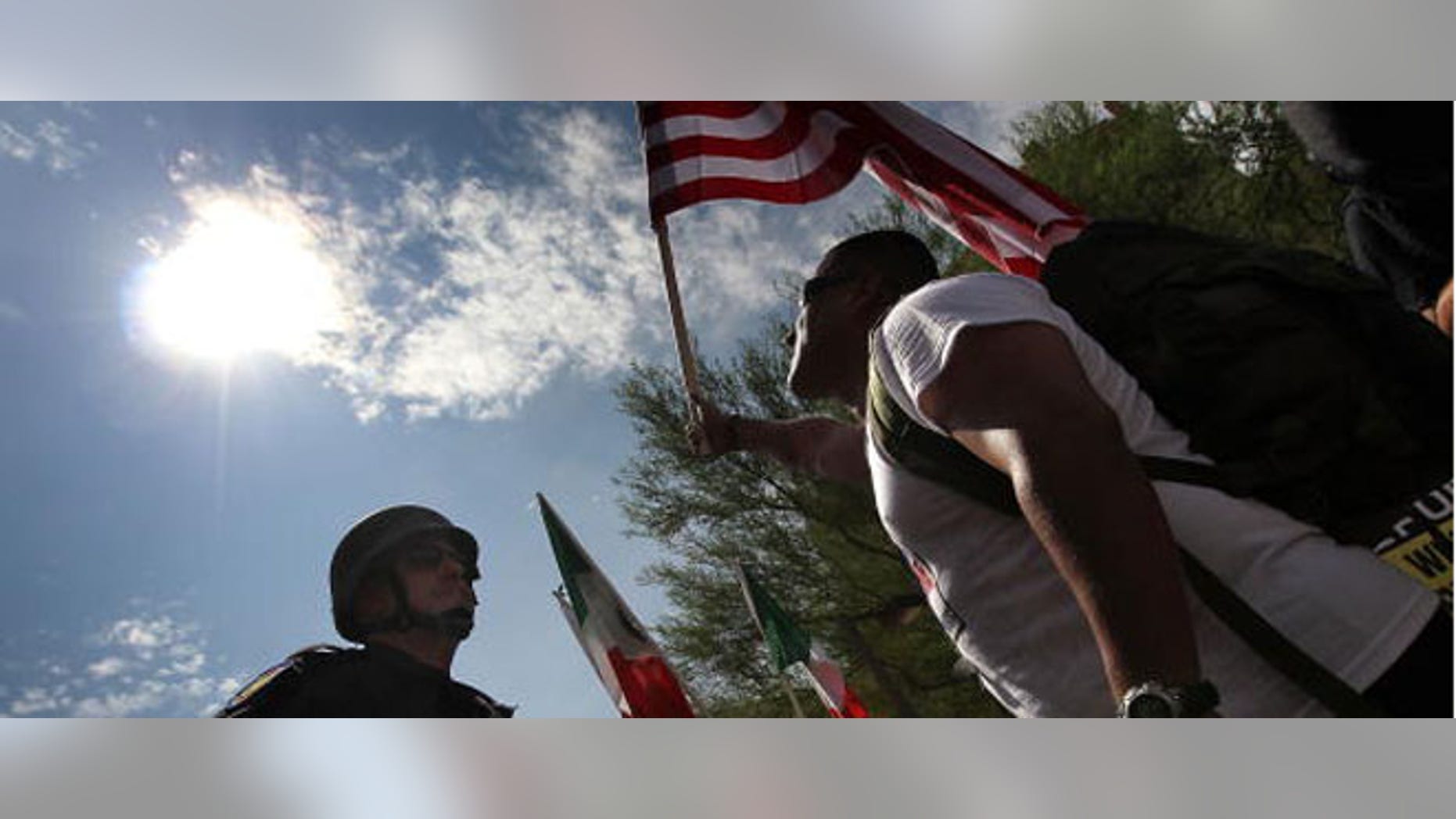 PHOENIX - JULY 29: Police and protesters face off during a demonstration against Arizona's immigration enforcement law SB 1070 on July 29, 2010 in Phoenix, Arizona. Protesters blocked a main downtown street in a show of civil disobedience to show opposition to the new law and riot police responded with arrests. U.S. District Court Judge Susan Bolton issued a preliminary injunction yesterday preventing several sections of Arizona's new immigration law from going into effect, at least until the courts have a chance to hear the full case. (Photo by John Moore/Getty Images)