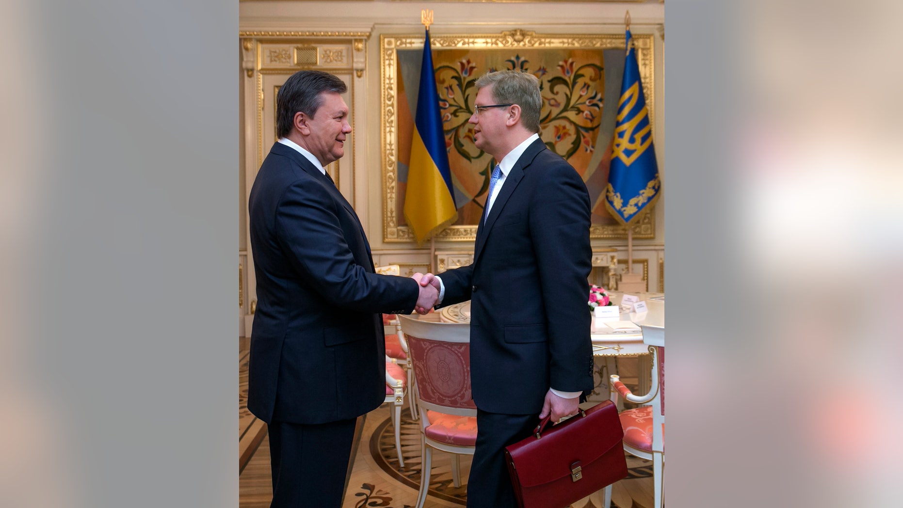 Ukrainian President Viktor Yanukovych, left, greets European Commissioner for Enlargement and European Neighborhood Policy Stefan Fule in Kiev, Ukraine, Wednesday, Feb. 12, 2014. (AP Photo/Andrei Mosienko, Pool)