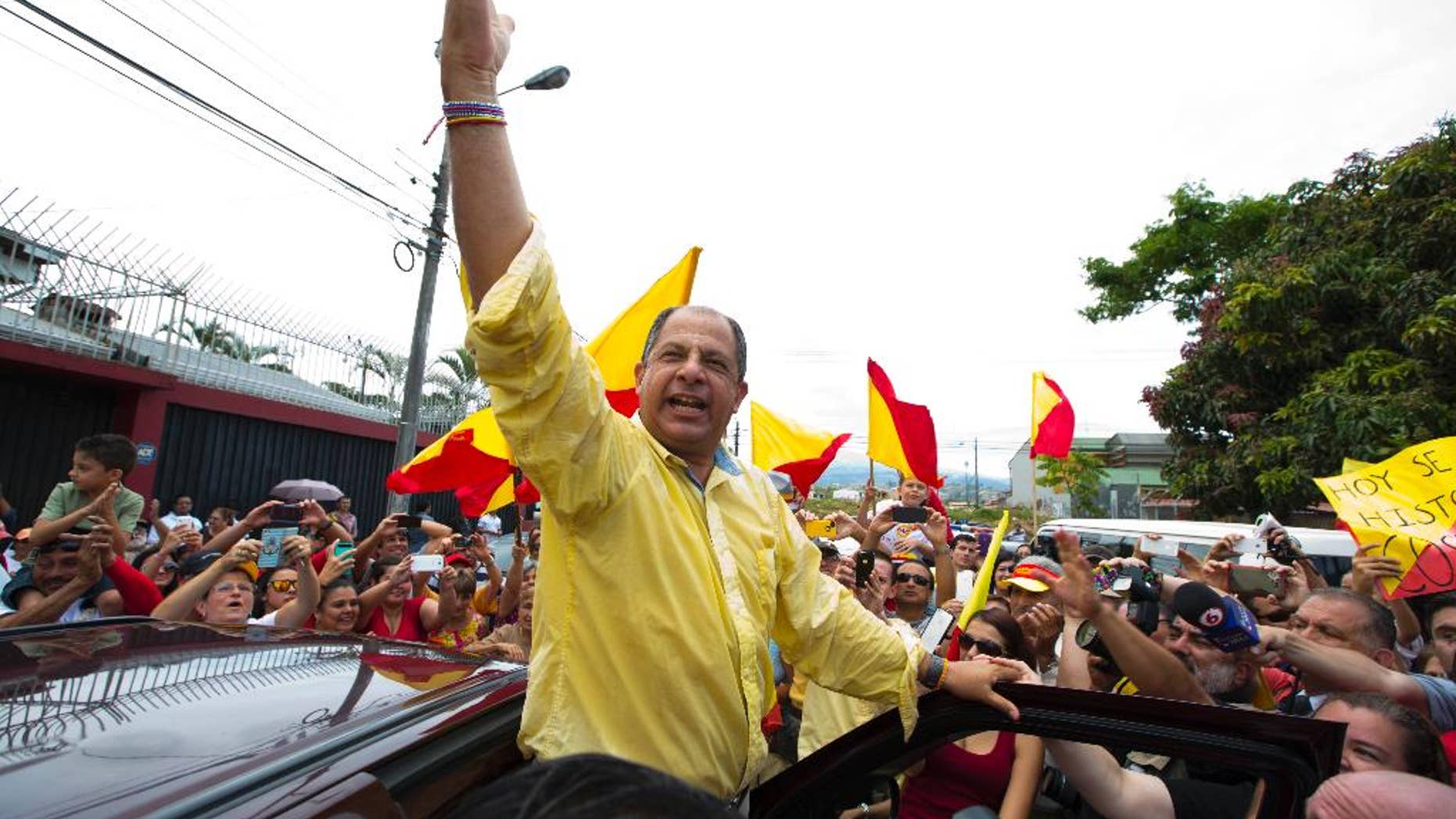 Luis Guillermo Solis, presidential candidate for the Citizen's Action Party, waves to supporters after casting his vote in the presidential runoff election in San Jose, Costa Rica, Sunday, April 6, 2014. Solis' only rival in the runoff dropped out of the race last month, leaving Solis one remaining challenge: getting enough Costa Ricans to the polls to give him a respectable vote total. (AP Photo/Moises Castillo)