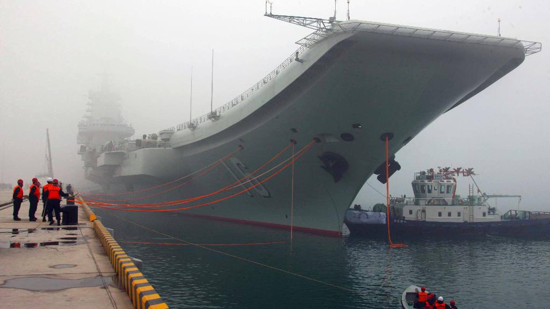 FILE - In this Feb. 27, 2013 file photo released by China's Xinhua news agency, China's first aircraft carrier, the Liaoning, is anchored in the northern port in Qingdao, east China's Shandong Province. Taiwan's defense ministry said China's sole aircraft carrier on Wednesday, Jan. 11, 2017 was transiting the Taiwan Strait amid heightened tensions between the mainland and self-governing island it claims as its own territory. (Wu Dengfeng/Xinhua via AP, File)