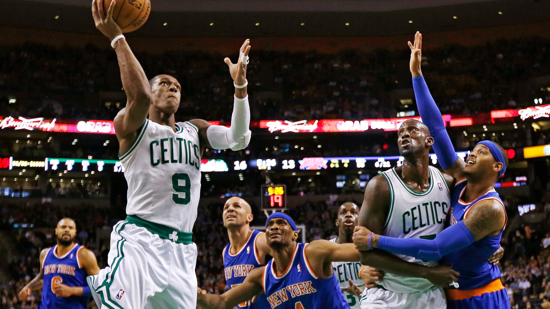 Boston Celtics guard Rajon Rondo (9) drives to the basket as Kevin Garnett blocks out New York Knicks forward Carmelo Anthony, right, during the first quarter of an NBA basketball game in Boston, Thursday, Jan. 24, 2013. (AP Photo/Charles Krupa)