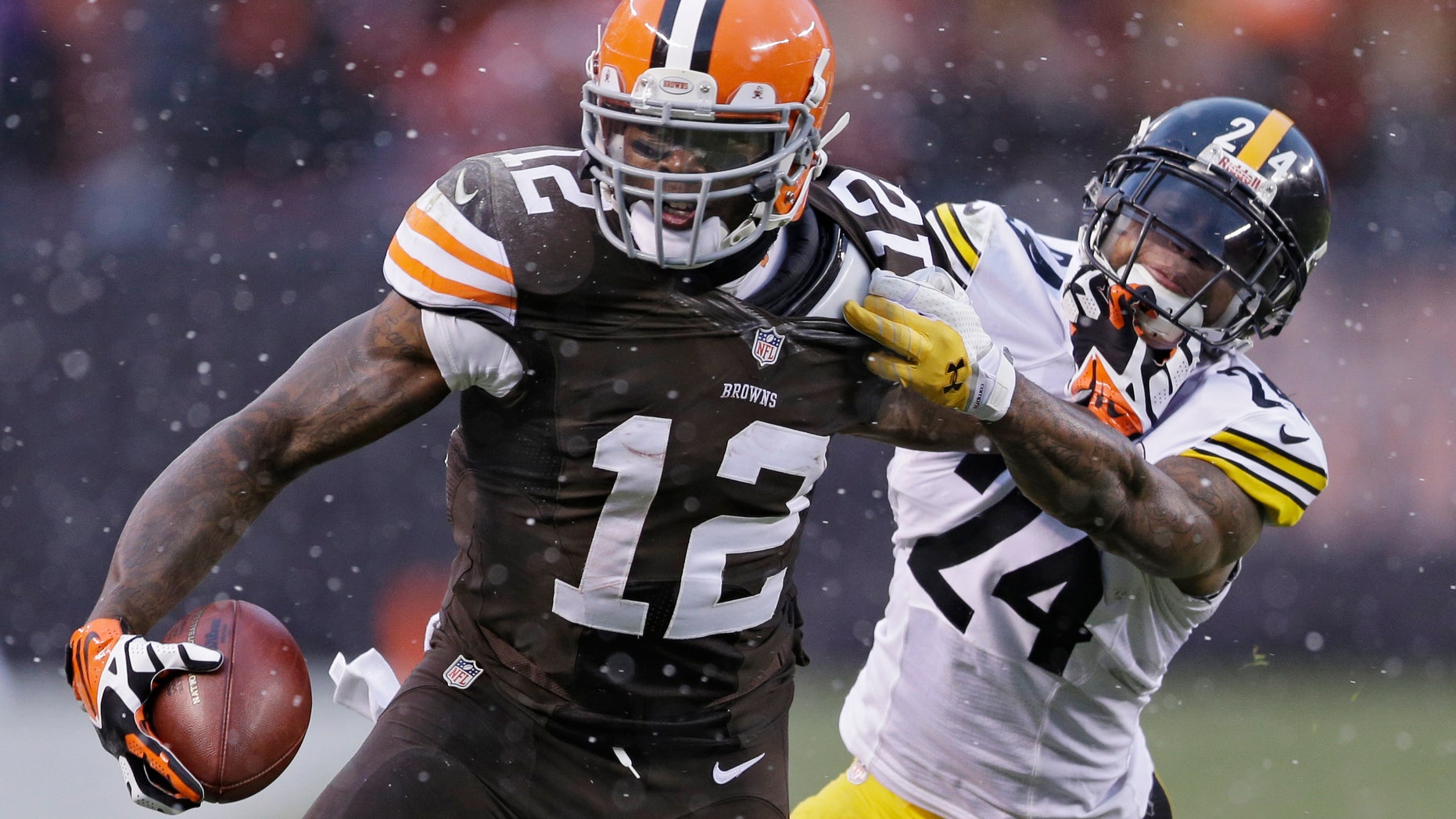 Cleveland Browns wide receiver Josh Gordon (12) is tackled by Pittsburgh Steelers cornerback Ike Taylor (24) after a catch in the fourth quarter of an NFL football game Sunday, Nov. 24, 2013, in Cleveland. The Steelers won 27-11. (AP Photo/Tony Dejak)