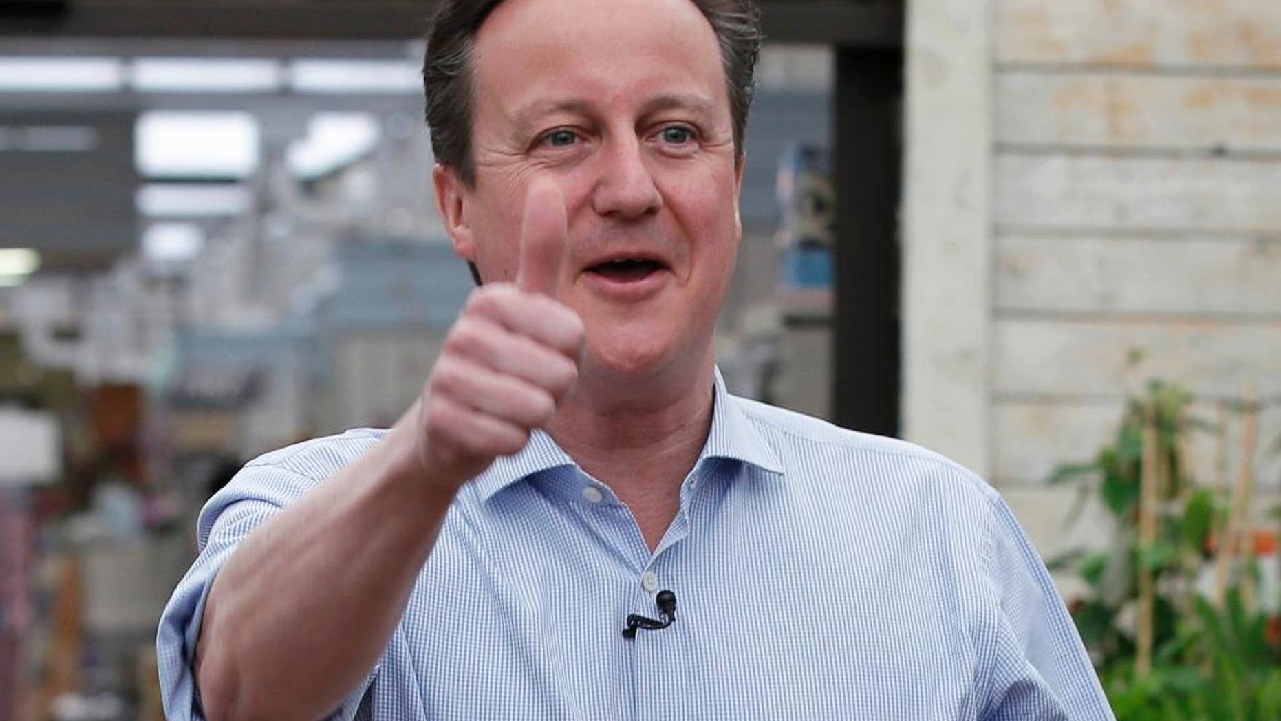 Britain's Prime Minister and Conservative Party leader David Camer gestures to supporters in Twickenham, London, Tuesday May 5, 2015. Britain will go to the polls in a national election on May 7. (AP Photo/Peter Nicholls, Pool)