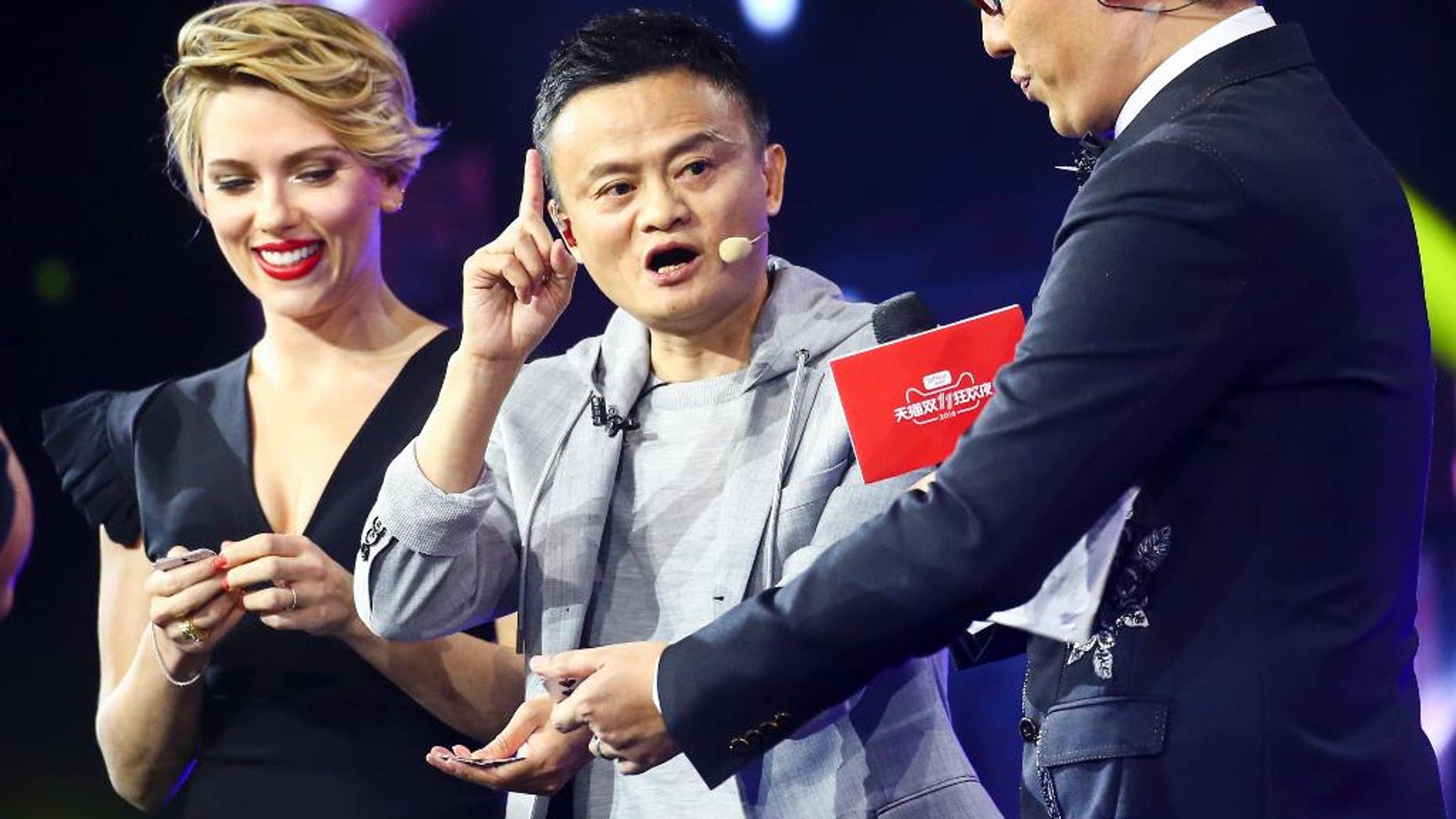 In this Thursday, Nov. 10, 2016 photo, Hollywood actress Scarlett Johansson, left, and Alibaba Group Chairman Jack Ma, center, attend an evening gala on the eve of the Singles Day online shopping festival in Shenzhen in southern China's Guangdong province.
