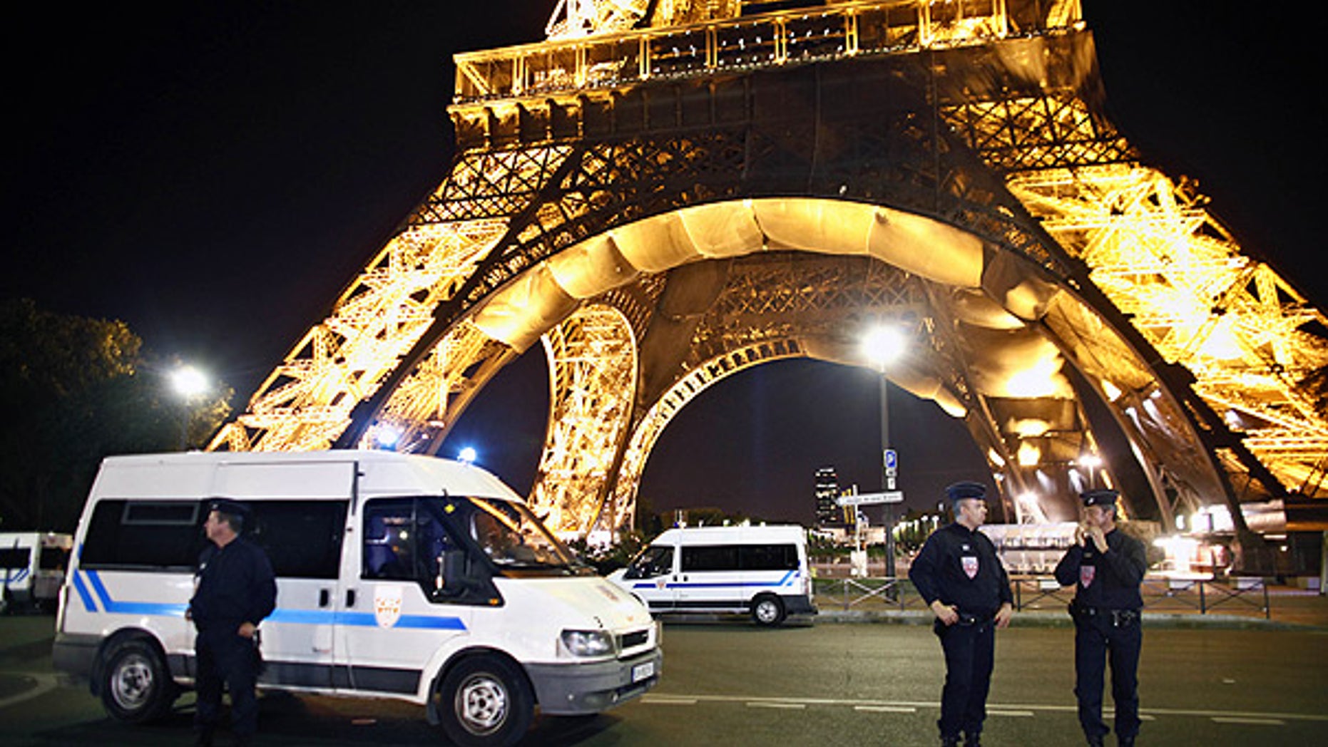 Police officers stand in front of the Eiffel Tower, in Paris, after an anonymous caller phoned in a bomb threat.