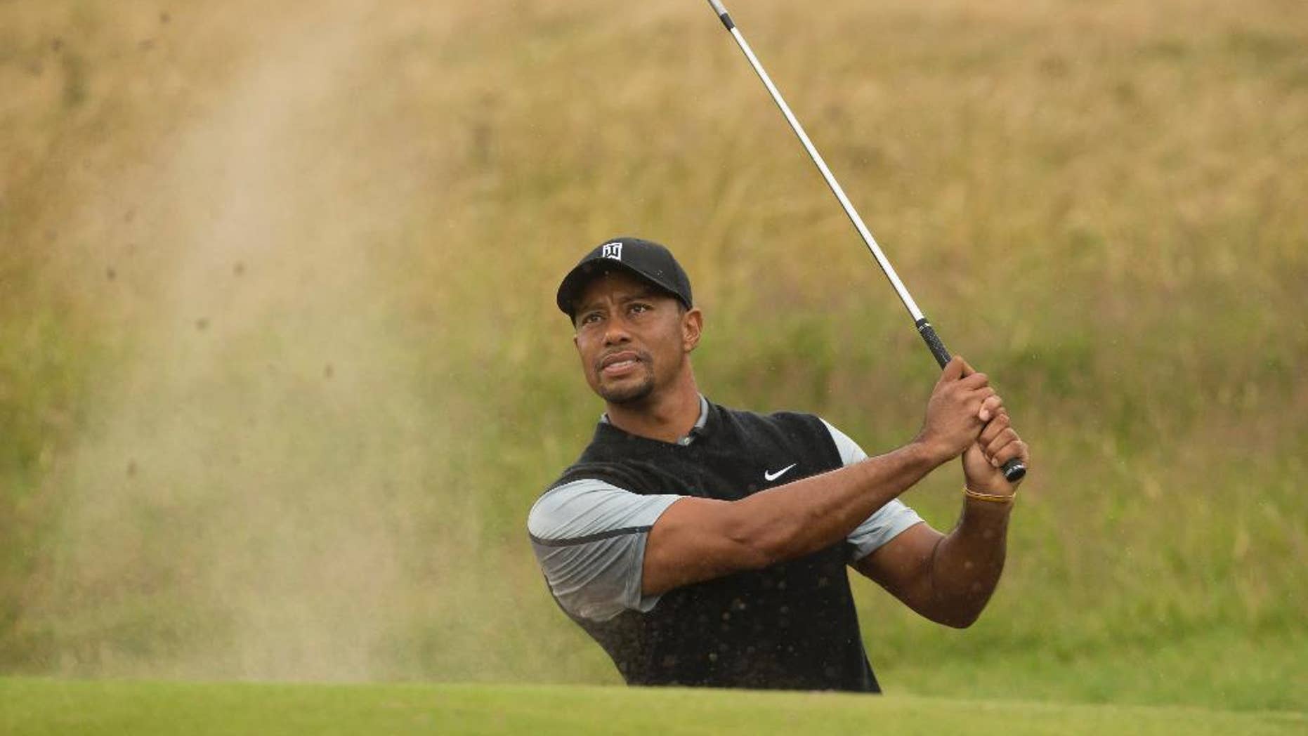Tiger Woods of the US plays a shot from the bunker near the 15th green during a practice round at Royal Liverpool Golf Club prior to the start of the British Open Golf Championship, in Hoylake, England, Saturday, July 12, 2014. The 2014 Open Championship starts on Thursday July 17. (AP Photo/Jon Super)