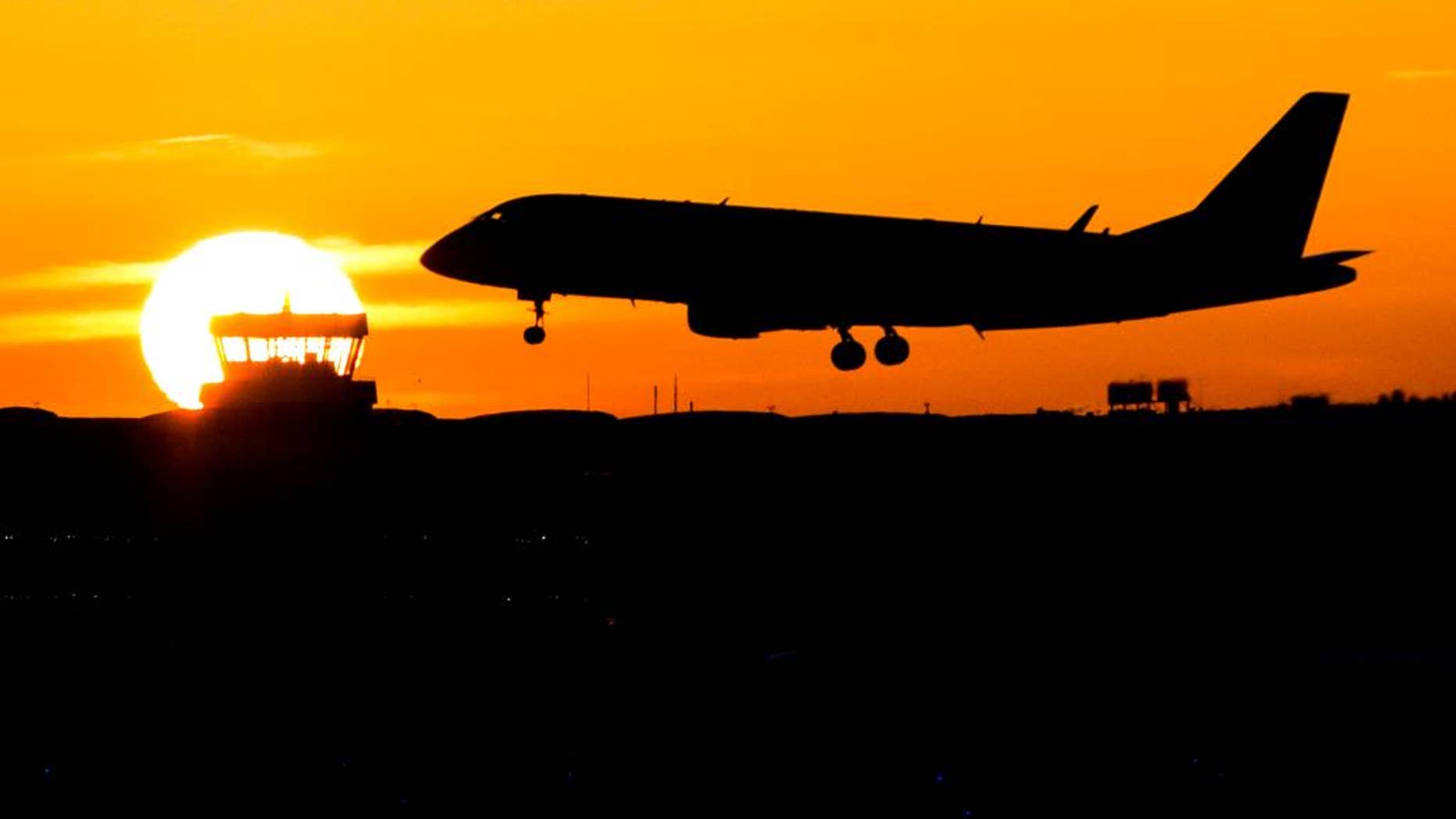 A plane lands during sunrise at the airport in Duesseldorf, Germany, Friday, Nov. 25, 2016. Lufthansa pilots will continue their strike at least until Saturday. (Marcel Kusch/dpa via AP)