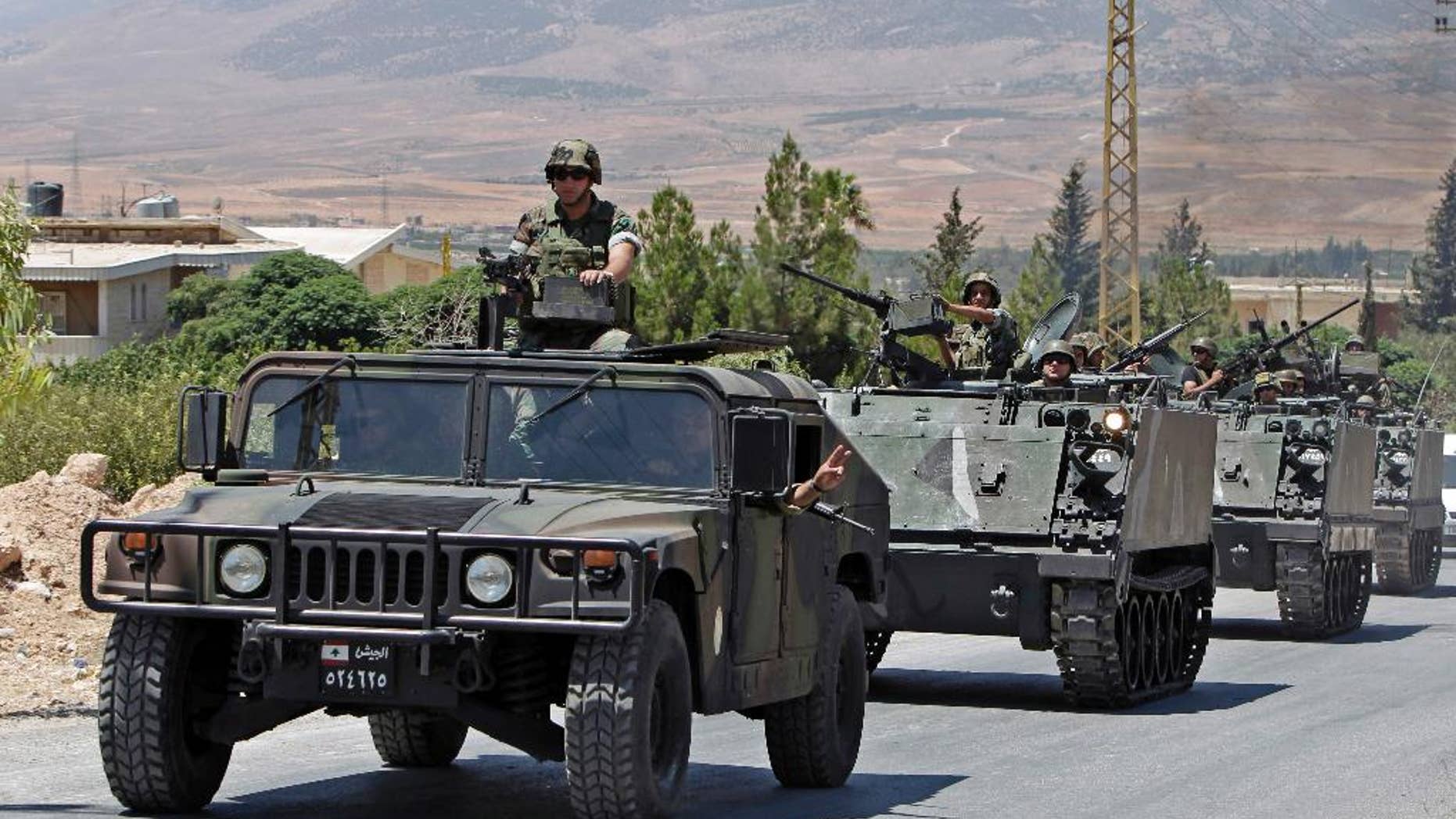 FILE - In this Aug. 4, 2014, file photo, Lebanese army reinforcements arrive at an area on the outskirts of Arsal, a predominantly Sunni Muslim town near the Syrian border in eastern Lebanon. A roadside bomb exploded near an army patrol in Arsal, wounding at least three soldiers, the military said Friday, Nov. 14. (AP Photo/Bilal Hussein, File)