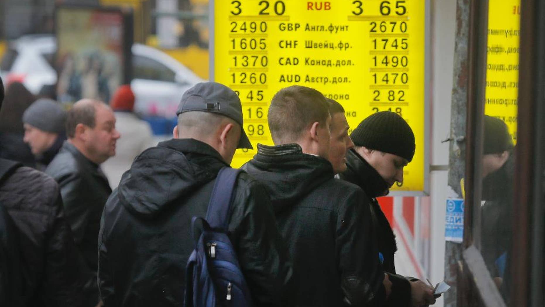 People stand in line at a currency exchange bureau in Kiev, Ukraine, Thursday, Nov. 13, 2014. Ukraine's hryvnia plunged to UAH 15.56/USD on Nov. 13, a 14% decline since Nov. 5, when the National Bank of Ukraine reduced its interventions at the ForEx and allowed further weakening. Ukraine's national currency has already lost nearly 47% of its value this year, falling from UAH 8.1/USD. (AP Photo/Efrem Lukatsky)