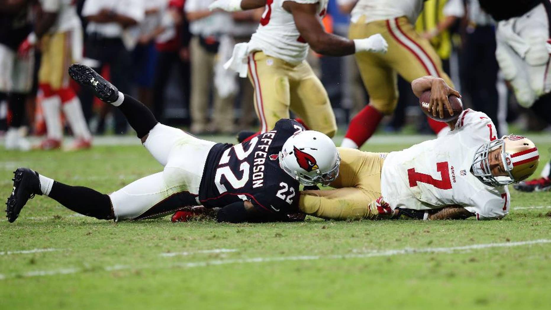 San Francisco 49ers quarterback Colin Kaepernick (7) is sacked by Arizona Cardinals free safety Tony Jefferson (22) during the second half of an NFL football game, Sunday, Sept. 21, 2014, in Glendale, Ariz. The Cardinals won 23-14. (AP Photo/Ross D. Franklin)