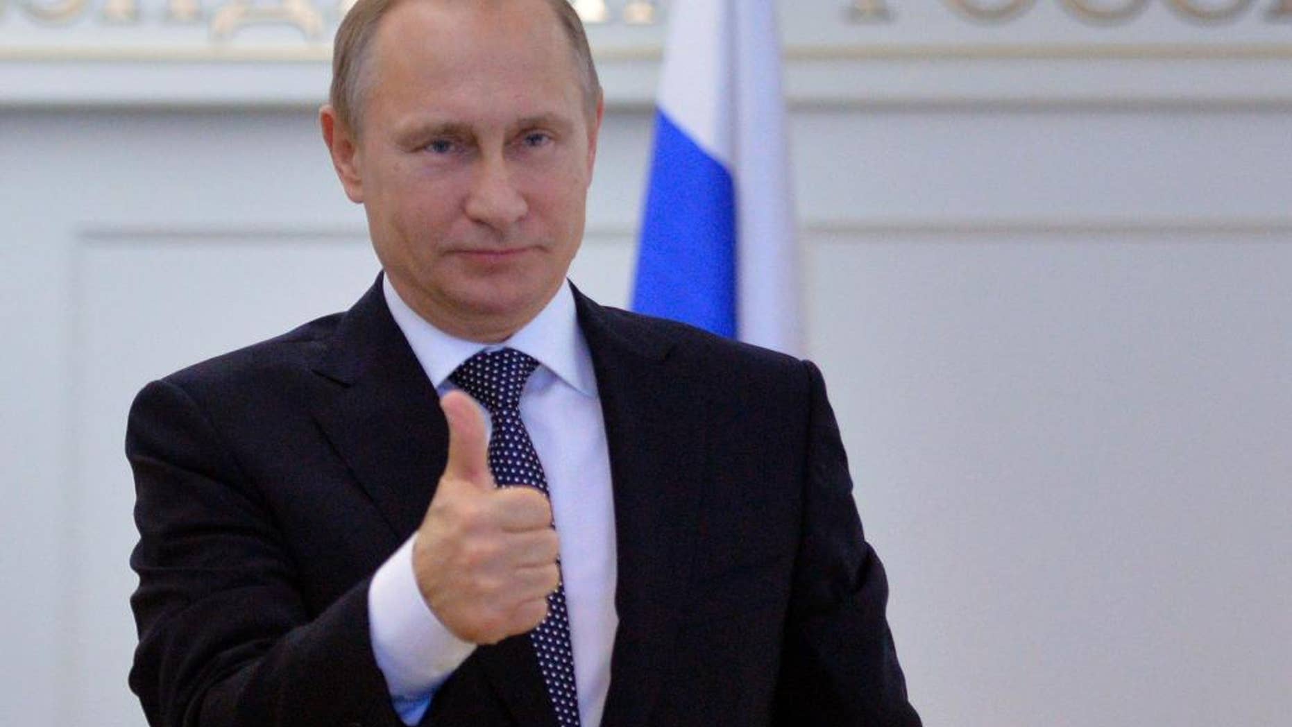 Russian President Vladimir Putin gives thumbs up during a live video link with Plesetsk Cosmodrome, as he watches a launch of Angara-A5 rocket booster in Moscow, Russia, on Tuesday, Dec. 23, 2014. (AP Photo/RIA Novosti, Alexei Druzhinin, Presidential Press Service)