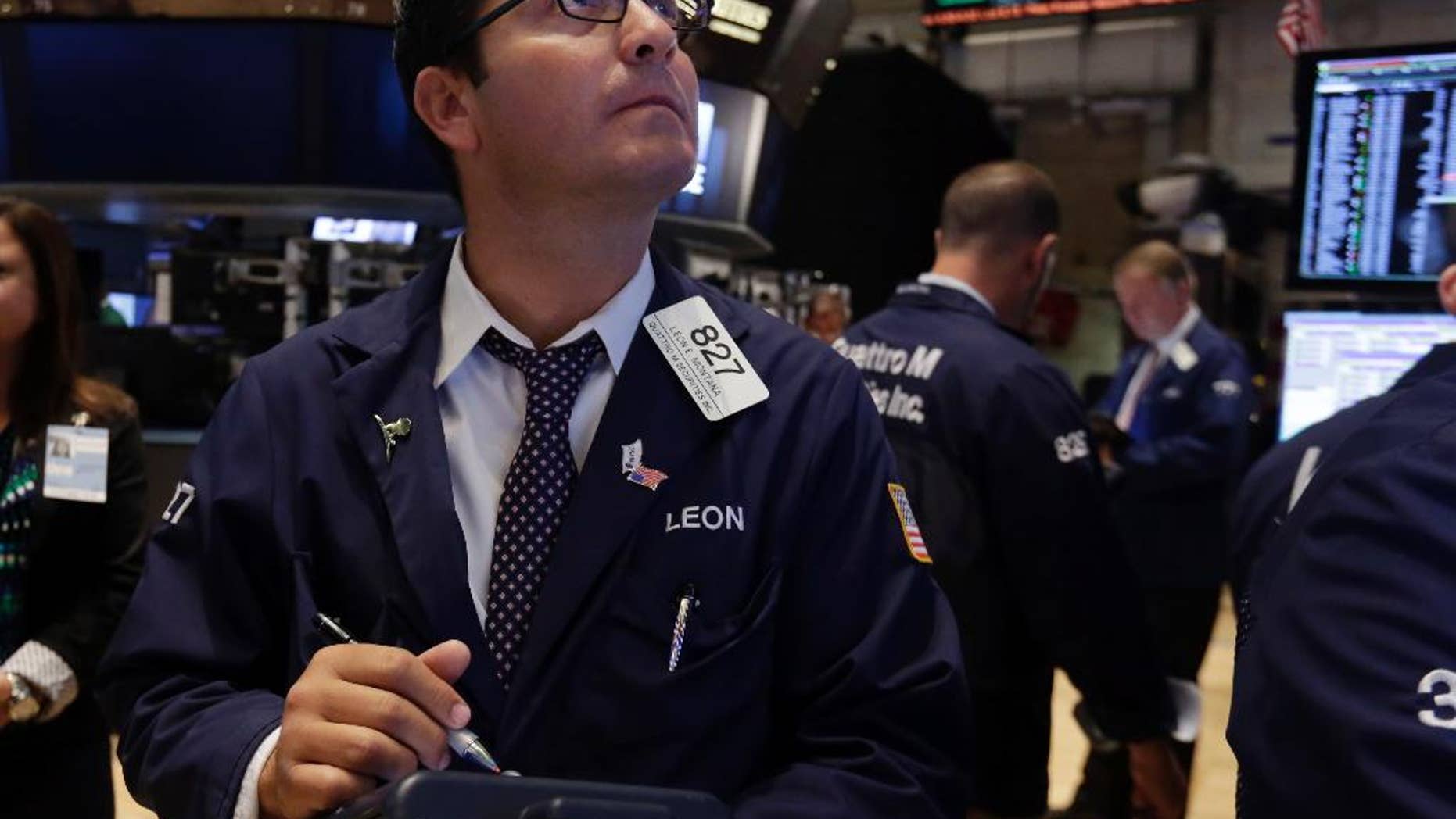 FILE - In this Tuesday, Aug. 19, 2014, file photo, trader Leon Montana works on the floor of the New York Stock Exchange. U.S. stocks opened slightly higher on Tuesday, Aug. 26, 2014, as investors weighed the latest batch of corporate deal news and mixed economic reports on home prices and demand for big-ticket items. The Standard & Poor's 500 index held at 2,000, extending the prior day's gains. (AP Photo/Richard Drew, File)