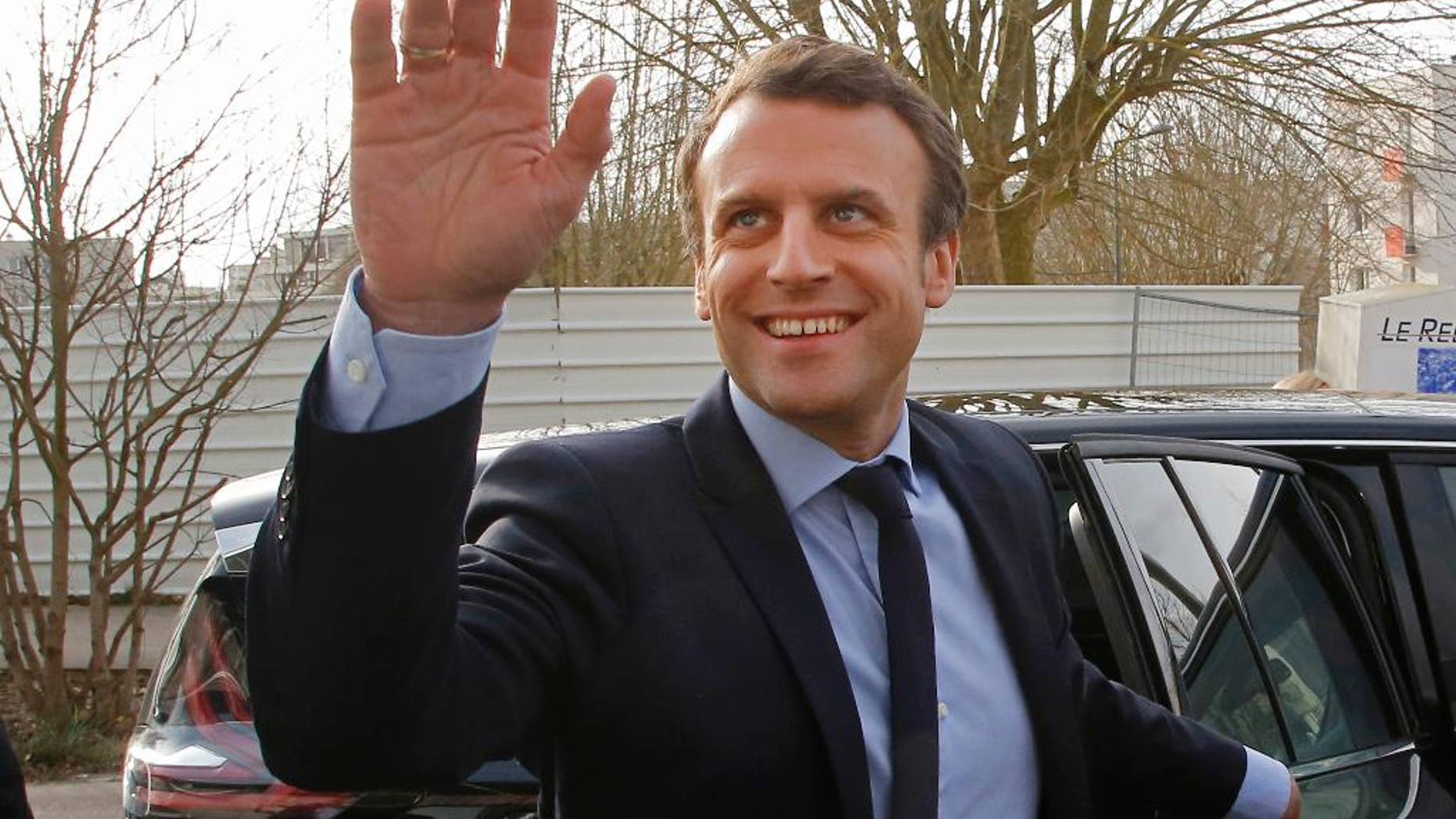 Independent centrist presidential candidate Emmanuel Macron waves to by standers as he arrives to visit the Moliere school in Les Mureaux, west of Paris, France, Tuesday, March 7, 2017. The first French presidential ballot will take place on April 23 and the two top candidates go into a runoff on May 7. (AP Photo/Michel Euler)