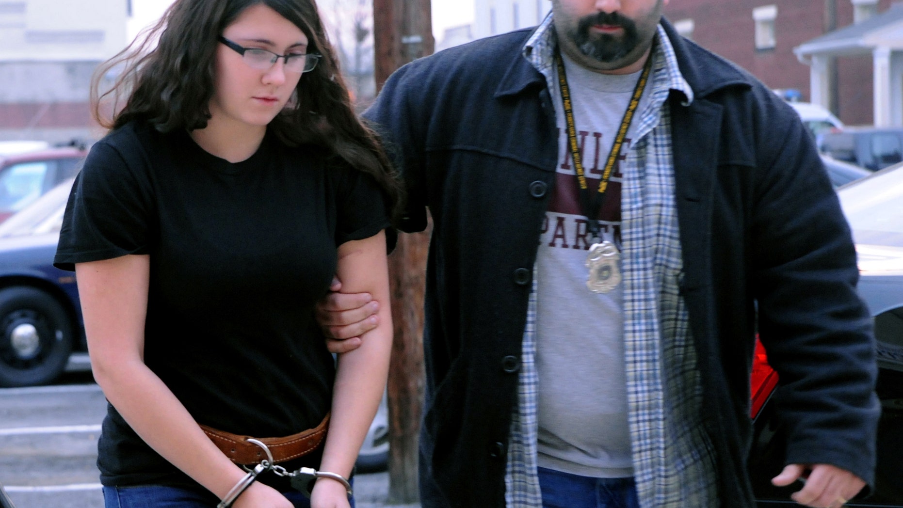 FILE - In this Tuesday, Dec. 3, 2013 file photo, Miranda K. Barbour is led into District Judge Ben Apfelbaum's office in Sunbury, Pa., by Sunbury policeman Travis Bremigen. Authorities say police have yet to substantiate Bremigen's claim that she killed more than 20 people in four states before the murder she is now charged with committing. Sonny Dean told The Daily Item newspaper on Wednesday, Feb. 19, 2014, that he believes his 19-year-old daughter, Miranda Barbour, may have been involved in one other murder besides the Nov. 11 fatal stabbing of Troy LaFerrara, 42, in Sunbury. (AP Photo/The News-Item, Mike Staugaitis, File) MANDATORY CREDIT