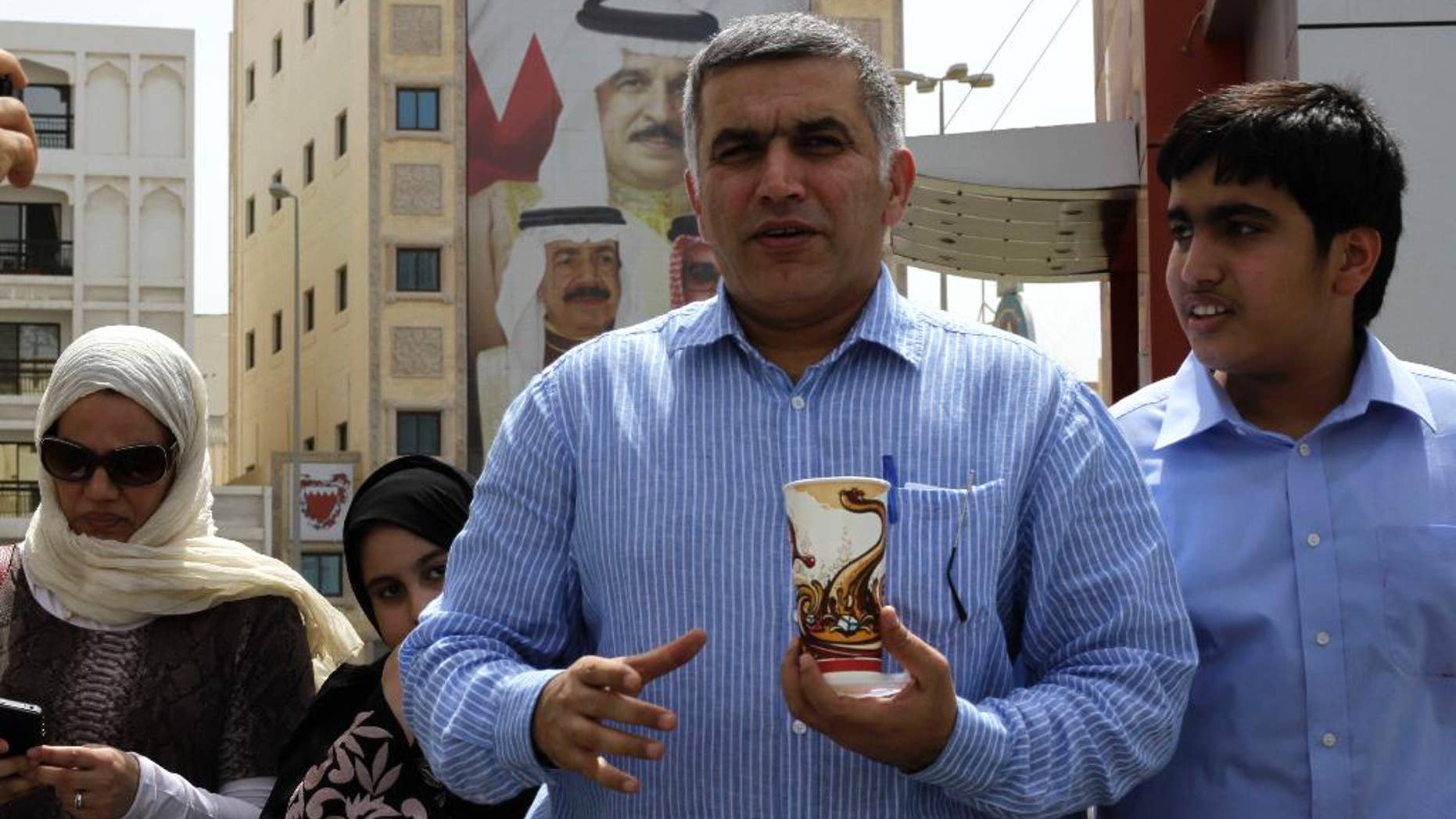 This May 28, 2011 photo, Bahraini human rights activist Nabeel Rajab, center, accompanied by his wife Sumaya, left, daughter Malak, second left, and son Adam, right, leaves a Manama, Bahrain, police station. Rajab was formally charged on Thursday, Oct. 9, 2014, with insulting the ministries of defense and interior. His court date was set for Oct. 19. Rajab was detained Oct. 1 over his tweets alleging that Bahrain’s security institutions were incubators for extremist ideology. His lawyer Jalila al-Sayed said he was also accused of “intimidating” security forces. (AP Photo/Hasan Jamali)