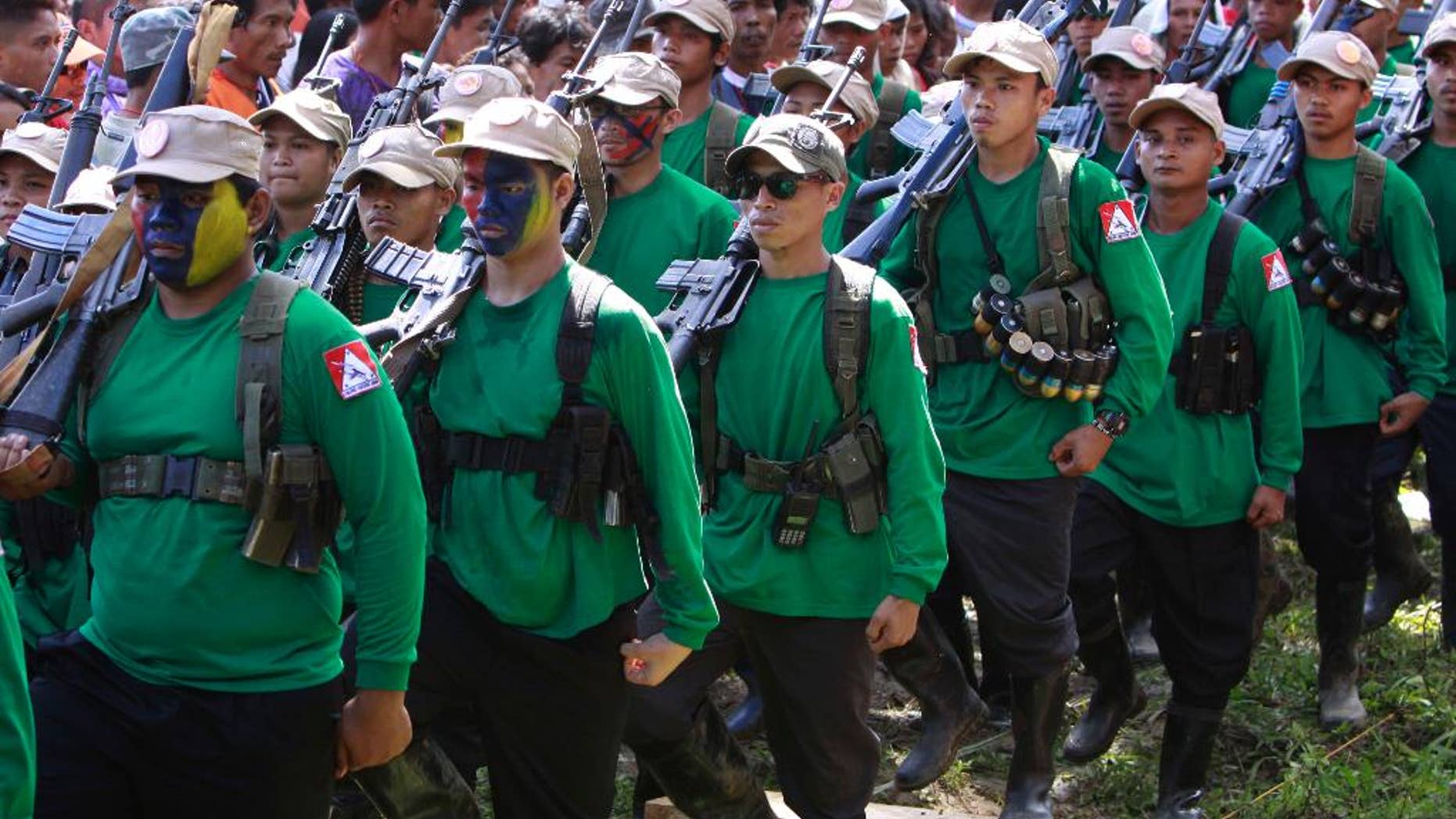 FILE - In this Dec. 26, 2010, file photo, communist New People's Army militants march in unison past local residents and supporters during the celebration of the 42nd anniversary of the Communist Party of the Philippines on Mount Diwata in southern Philippines. On Saturday, Aug. 20, 2016, Philippine President Rodrigo Duterte reimposed an indefinite cease-fire after communist guerrillas declared their own truce as both sides set the stage for a resumption of talks aimed at ending one of Asia's longest-running rebellions. (AP Photo/Pat Roque, File)